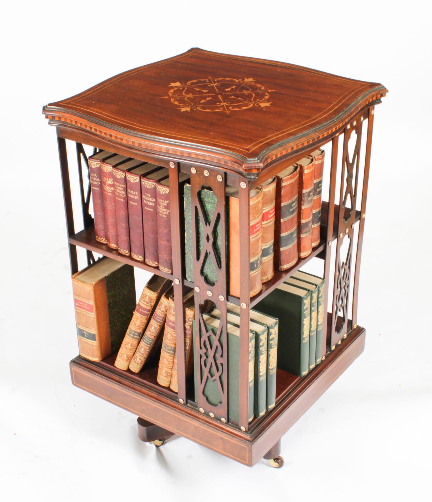 This is an exquisite English antique late Victorian mahogany and marquetry inlaid revolving bookcase, circa 1890 in date.
 
The top has elaborate circular foliate marquetry inlaid decoration to the centre  as well as satinwood crossbanding around