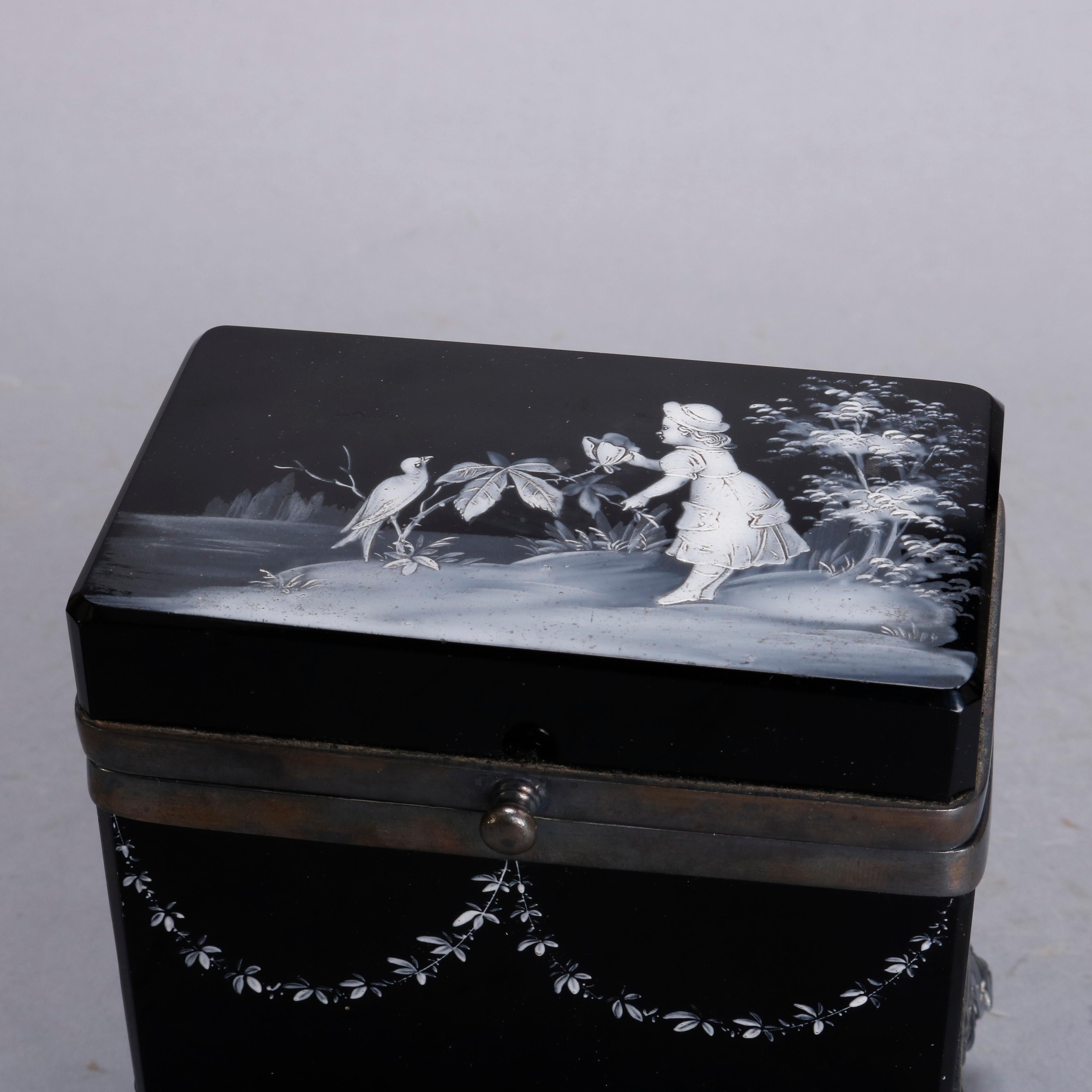An antique Victorian Mary Gregory dresser box offers black amethyst glass box with top decorated with scene of young girl lakeside with bird, sides with floral garland, and seated on quadruple-plated hard metal footed base, circa 1890

Measures: