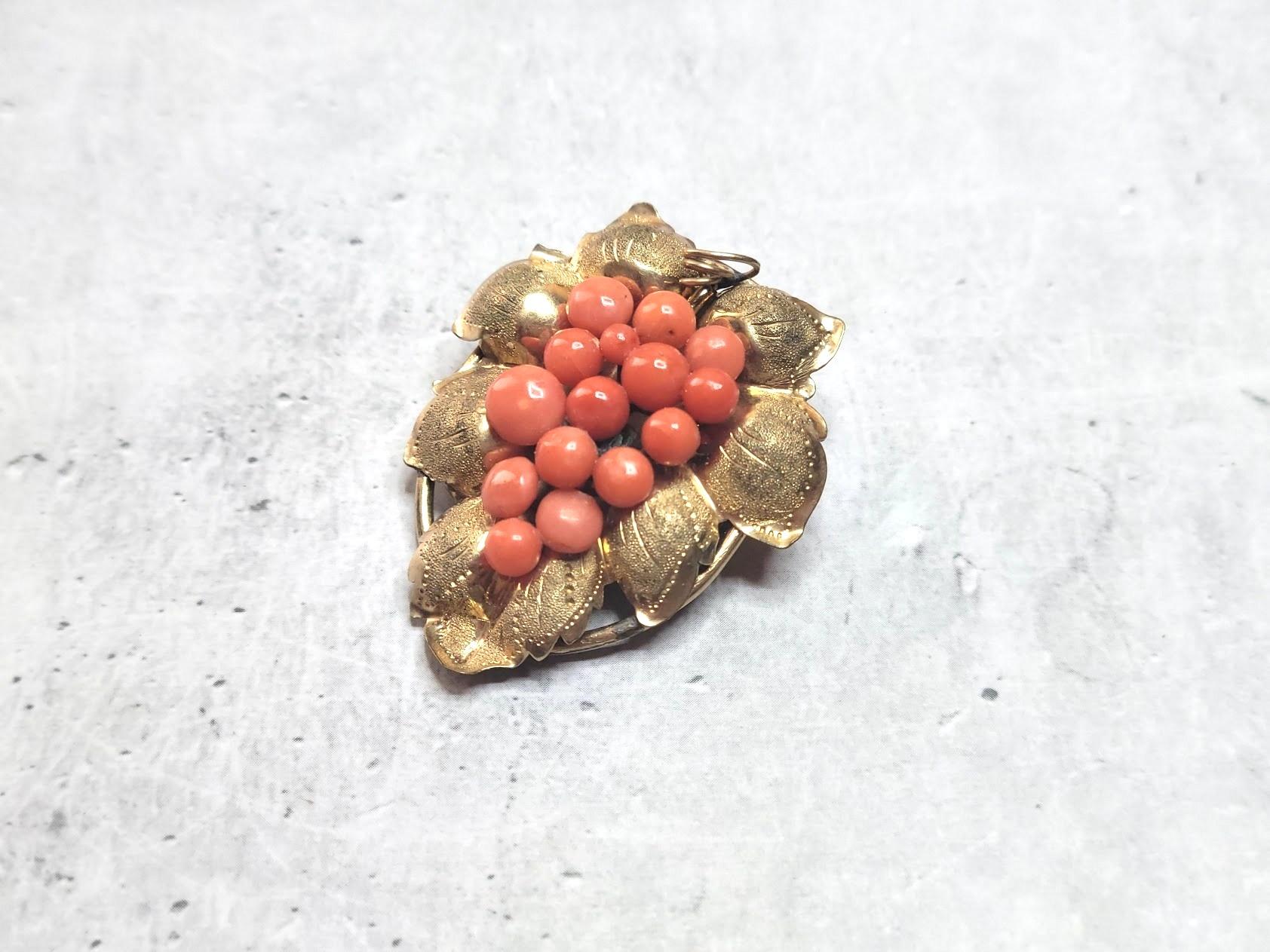 Discover this exquisite antique grape brooch from the Victorian Romantic era, featuring a natural Mediterranean coral. This brooch is a testament to the high skill of English jewelers during the Victorian period, and its timeless design is not