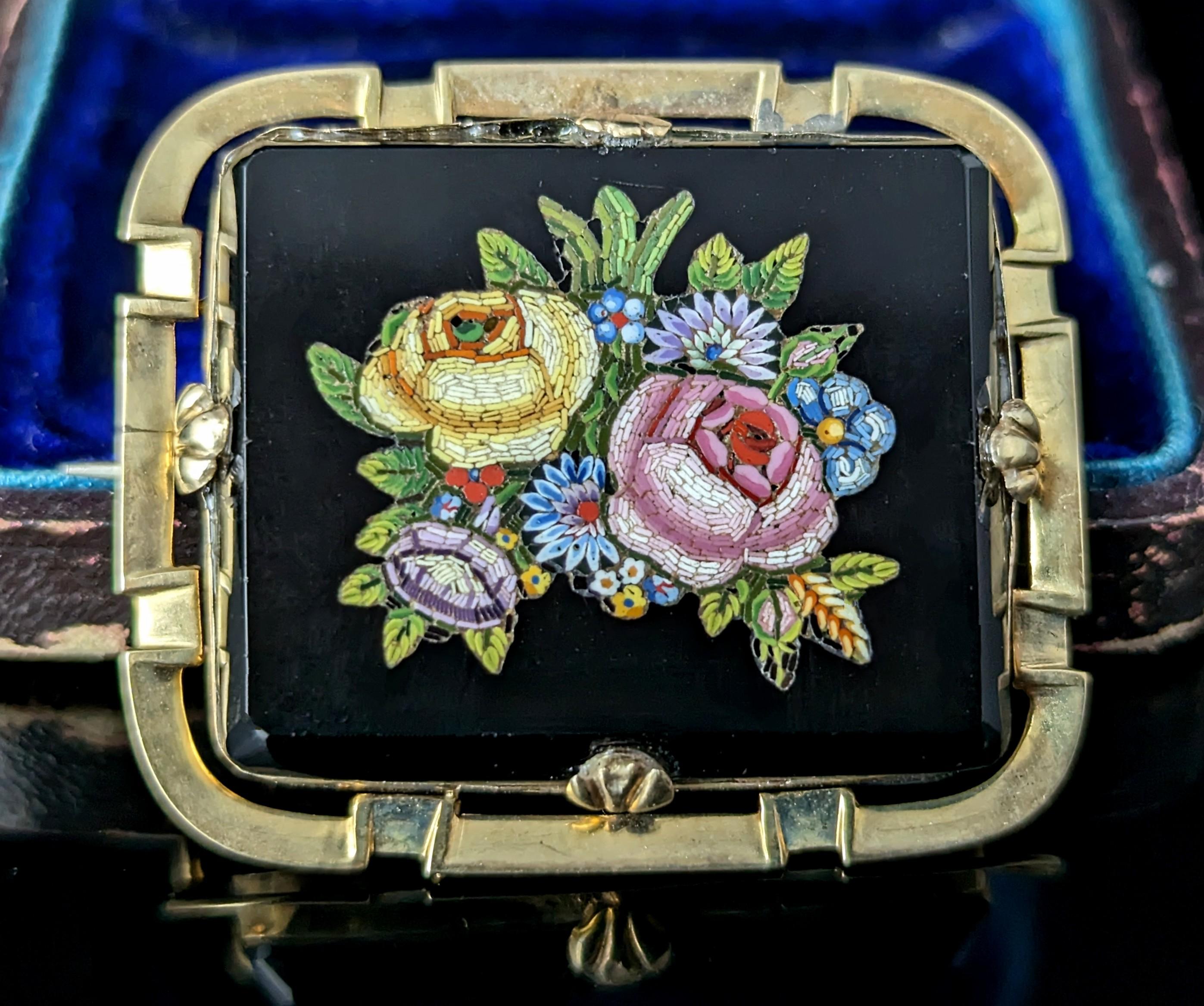 An attractive and highly detailed antique micro mosaic brooch.

A 19th century Grand Tour piece it depicts a finely done image of a floral display the tesserae set into a rich inky black glass which resembles black onyx.

The floral display is