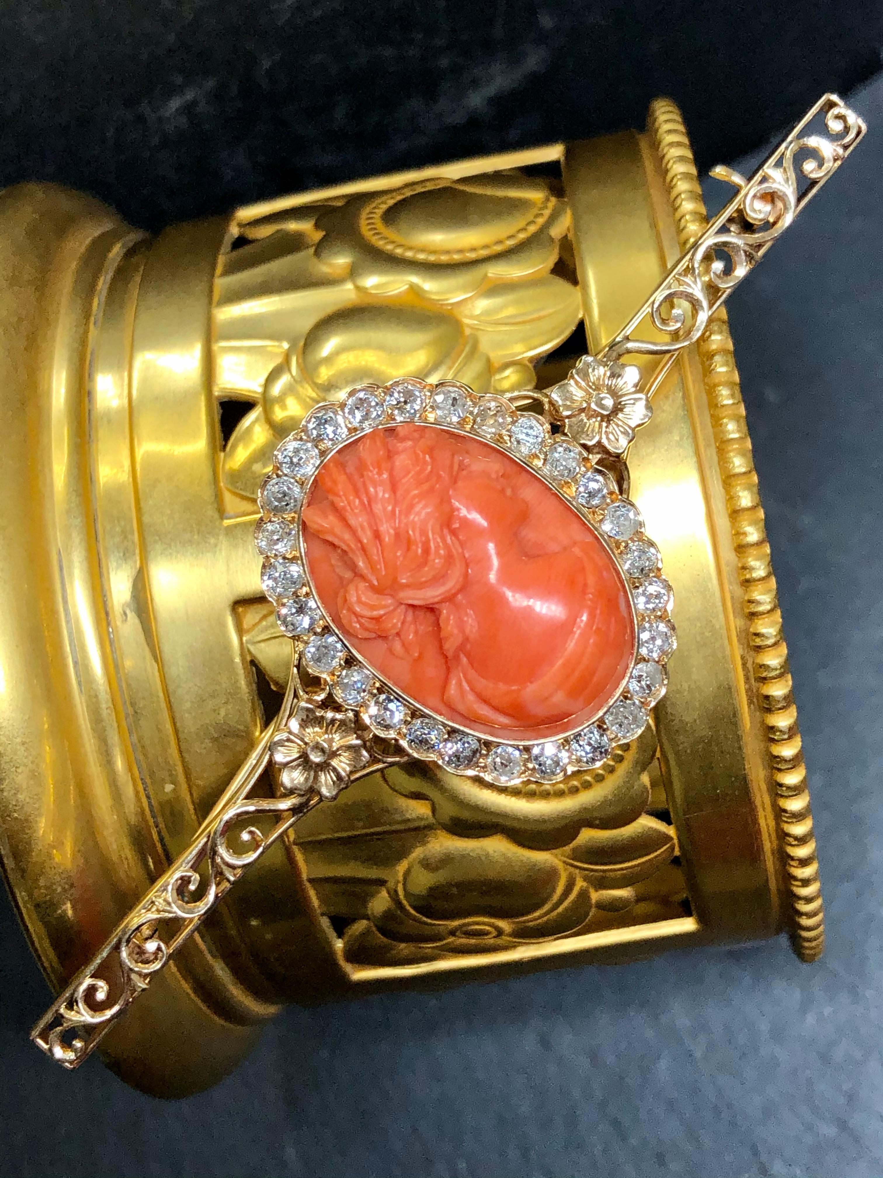 An original antique Victorian brooch done in 14K yellow gold and set with approximately 2.16cttw in Si1 to imperfect antique mine-cut diamonds (two stones chipped) and centered by a beautifully carved coral cameo. An impressive piece of jewelry