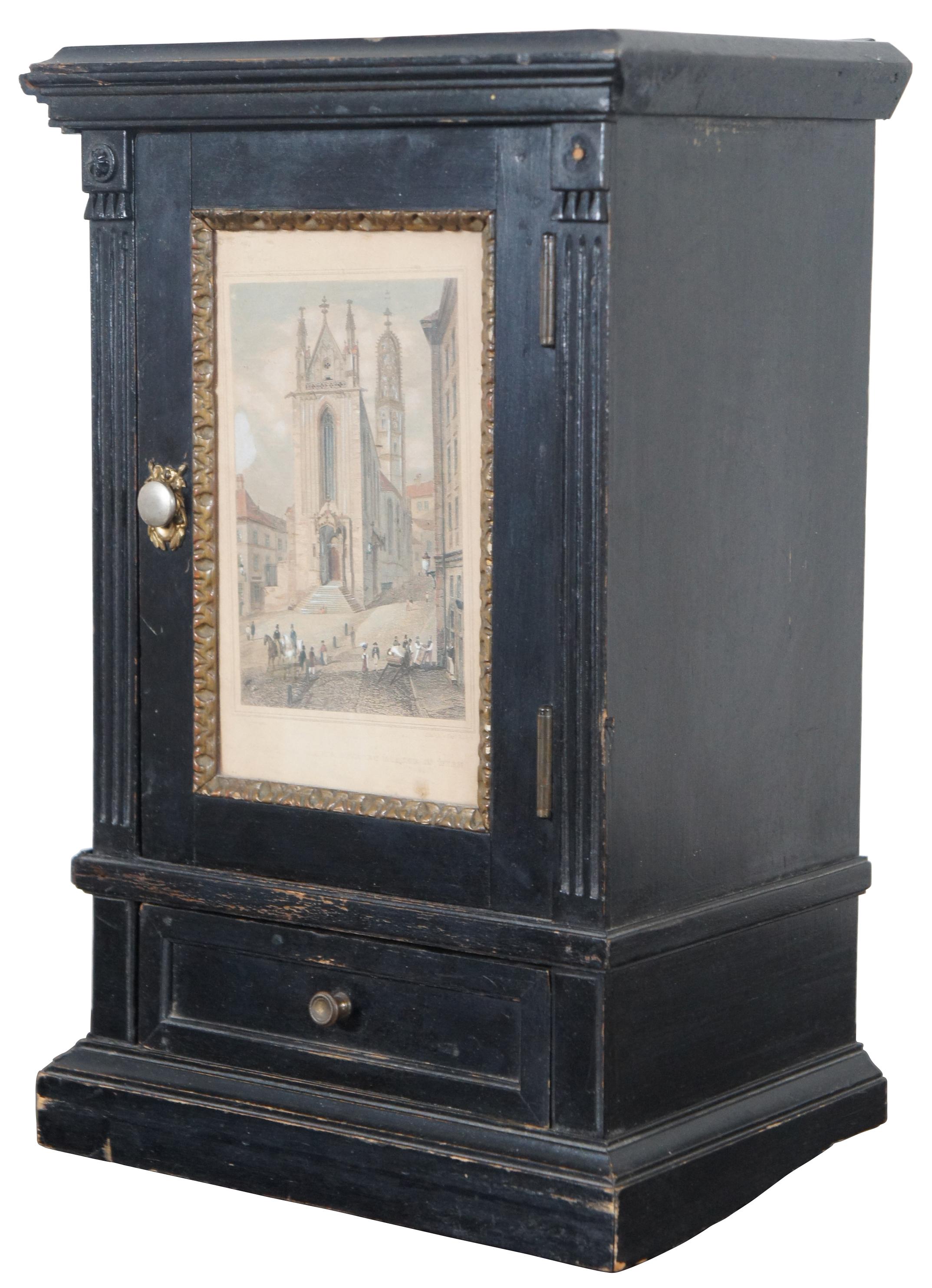 Antique black painted miniature cabinet with lower drawer, three interior shelves and door displaying an antique print by Carl Rauch titled Ansicht der Maria Stiegen Kirche in Wien (View of Mary by the Shore Church in Vienna). “Maria am Gestade or