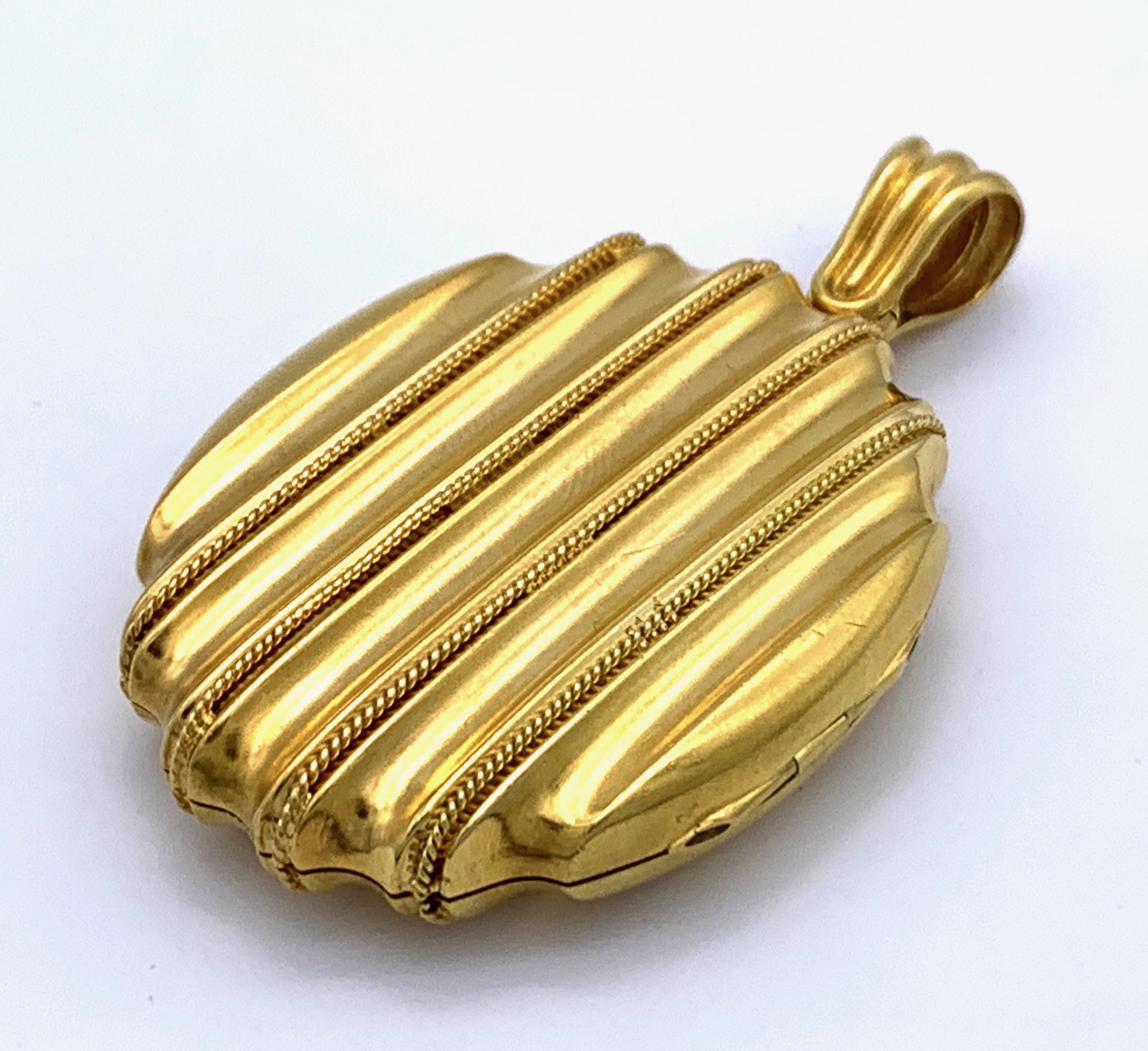 The oval locket is made out of two-coloured 15K gold and decorated with twisted gold wire. On the inside are the original gold frames. 
This chunky locket is a fine example of Victorian modernist design. 