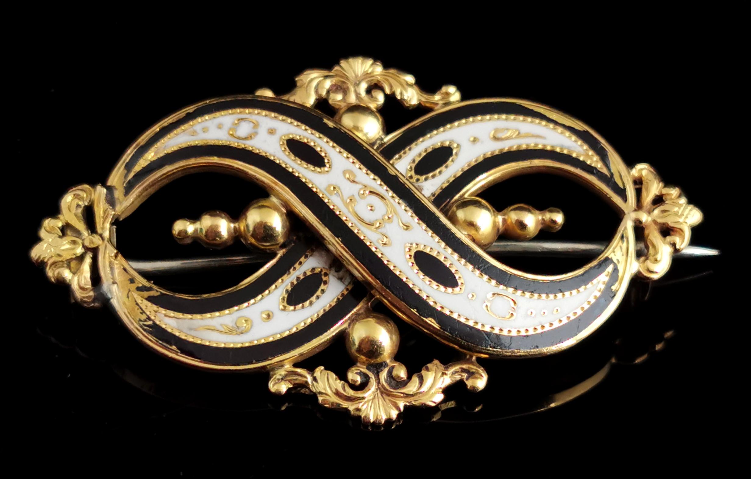 A stunning antique, late Victorian 15kt yellow gold and enamelled mourning brooch.

A very elegant and elaborate design the brooch features two overlapping arches joined each end to form an infinity symbol.

Symbolising remembering someone