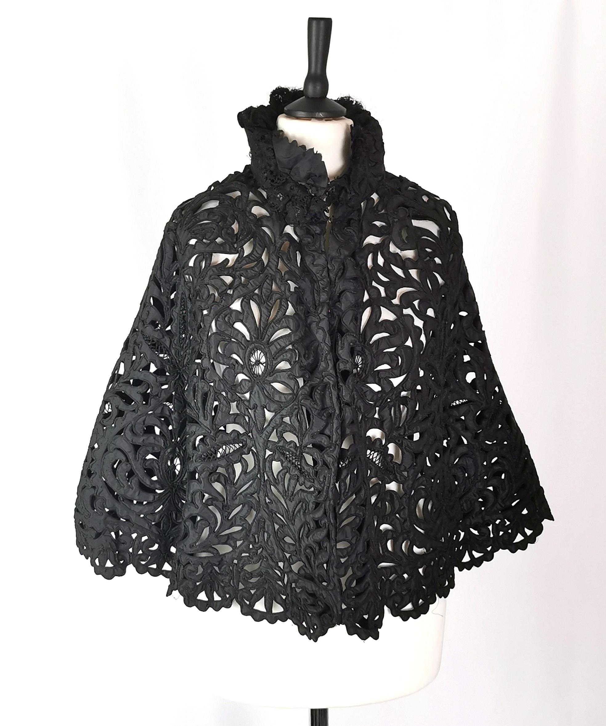 Una bellissima mantella da lutto vittoriana con uno splendido pizzo a nastro con disegno ritagliato.

È realizzato in pizzo a nastro pesante con rifiniture in raso e pizzo.

Si chiude sul davanti con ganci e occhielli, un design bellissimo e