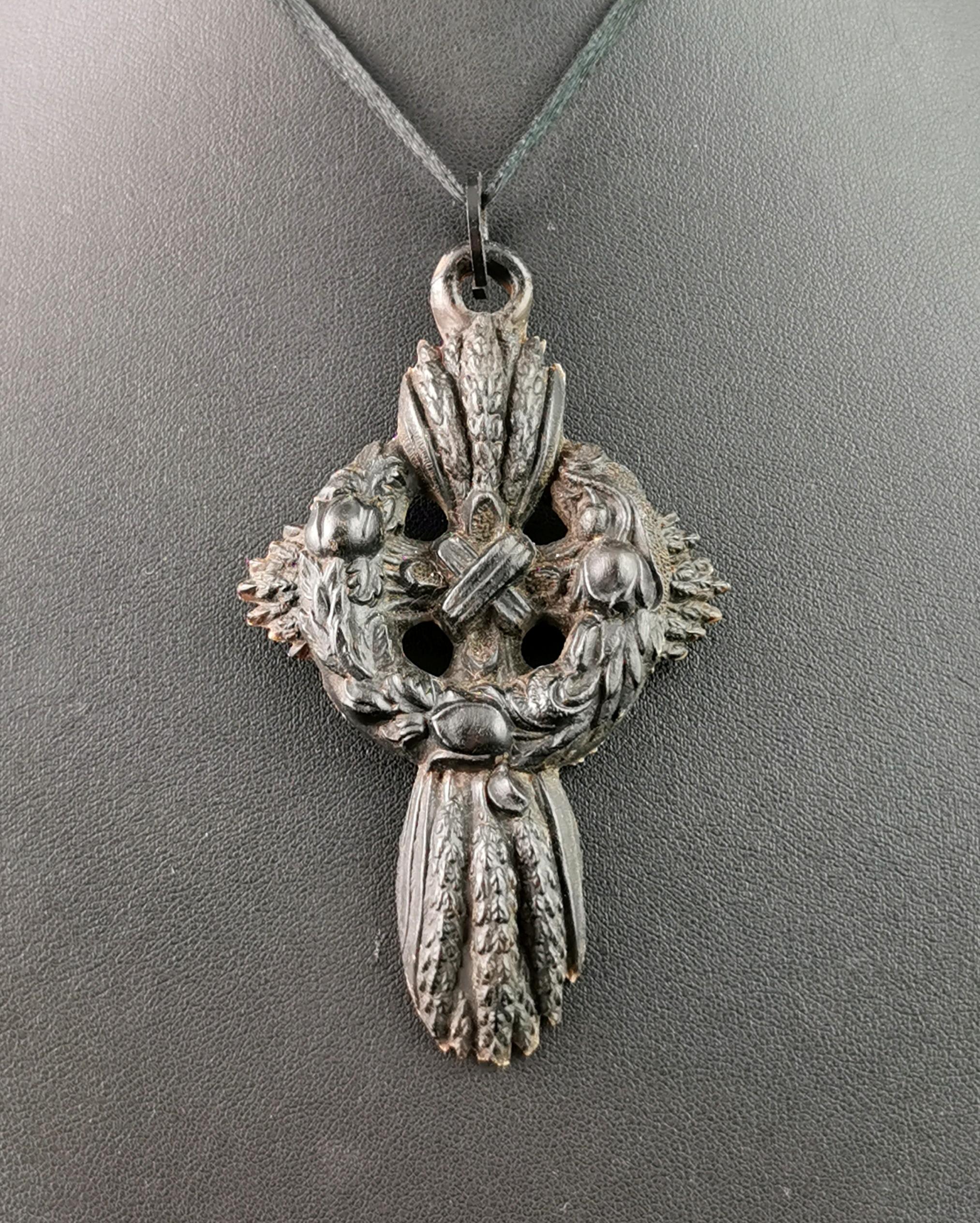 A beautiful antique, Victorian era mourning Cross pendant.

So much attention to detail the cross is made up from sheaths of wheat with a central wreath featuring tulips.

The cross is relatively large and has a black japanned loop from the top for