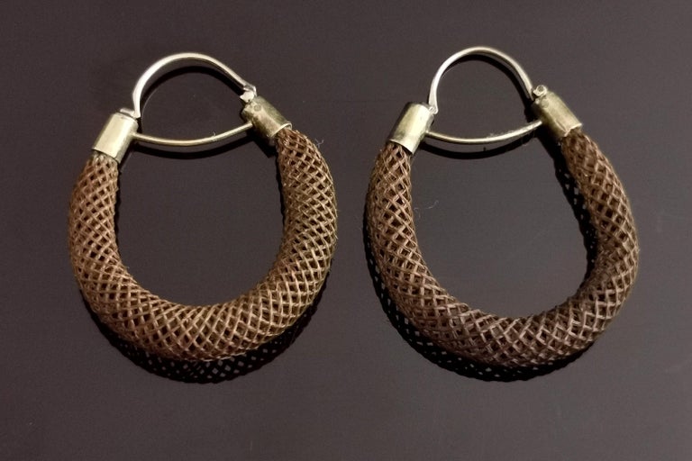 A gorgeous pair of Antique Victorian hairwork earrings.

Intricately woven and strengthened hair woven carefully to form an oval hoop in a hollow tube.

They have 9kt gold cap ends and a 9kt gold latch back wire fitting for pierced ears.

These