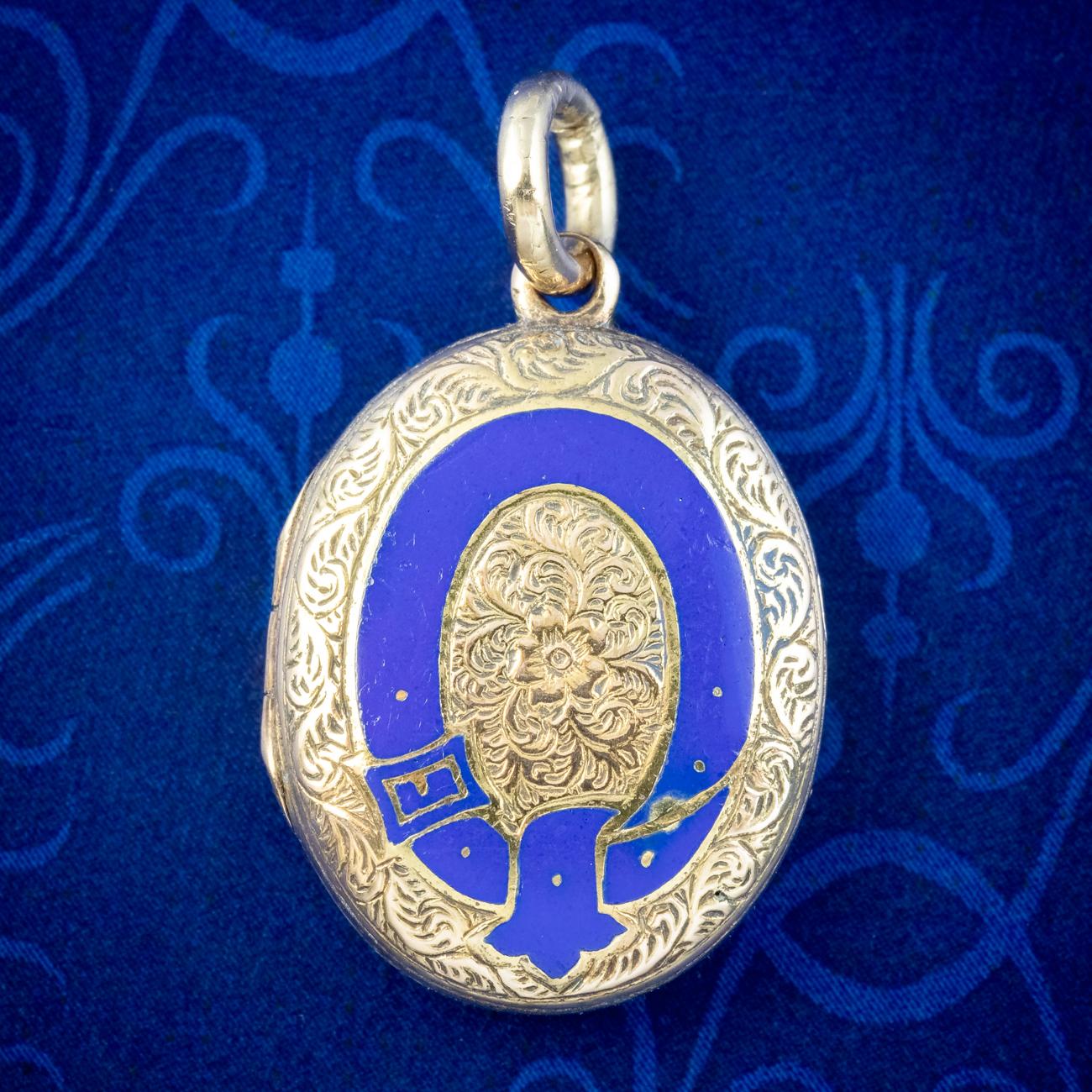 A petite antique Victorian Mourning locket fashioned in 9ct gold with scrolling, foliate artistry chased across both sides and a circular belt and buckle on the front highlighted in royal blue enamel with a forget me not in the centre, both