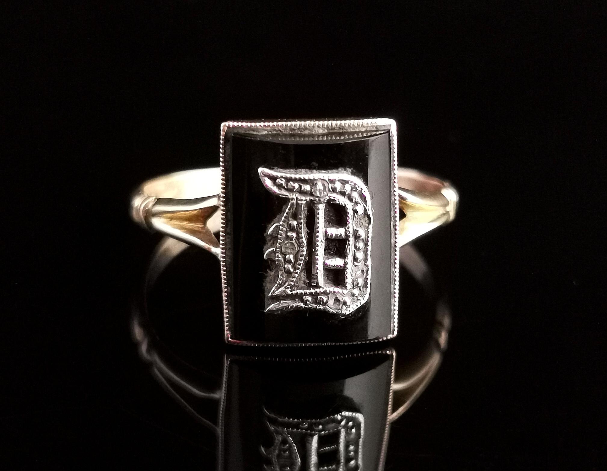 A gorgeous antique, late Victorian era mourning ring.

This is an initial ring with an applied silver letter D, lightly engraved in gothic script and set with Diamond chips, set on a rich black onyx panel.

The ring has decorative shaped shoulders