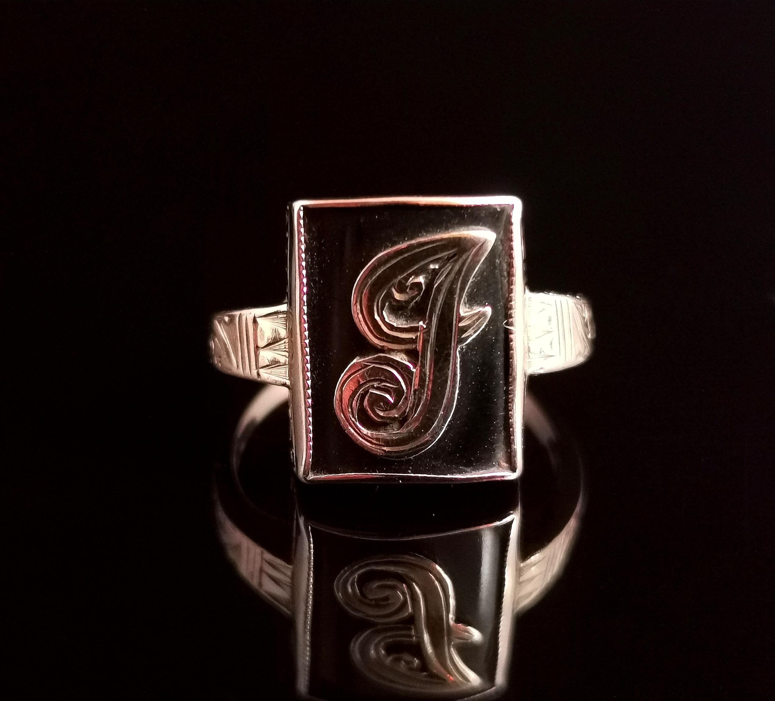 A gorgeous antique, late Victorian era mourning ring.

This is an initial ring with an applied gold letter J, set on a rich black onyx panel.

The ring has decorative engraved shoulders and stone setting and a smooth polished band at the back, a