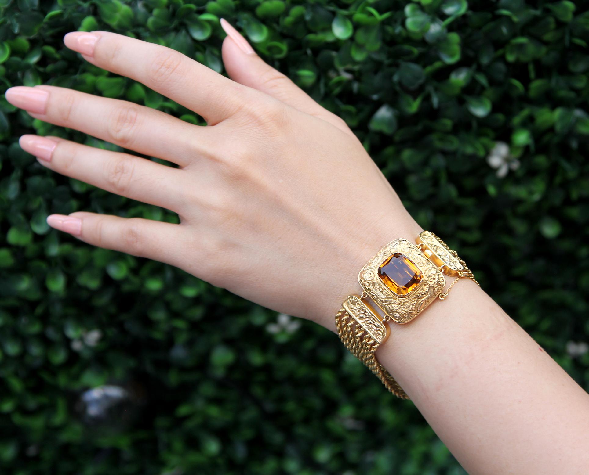 Ein antikes viktorianisches Armband mit mehreren Strängen, besetzt mit Citrin in 14/15 Karat Gelbgold. 
Im Mittelpunkt des Armbands steht ein gelb-orangefarbener Citrin im Kissenschliff, der mit einer Goldprägung aus Blüten und Blättern verziert