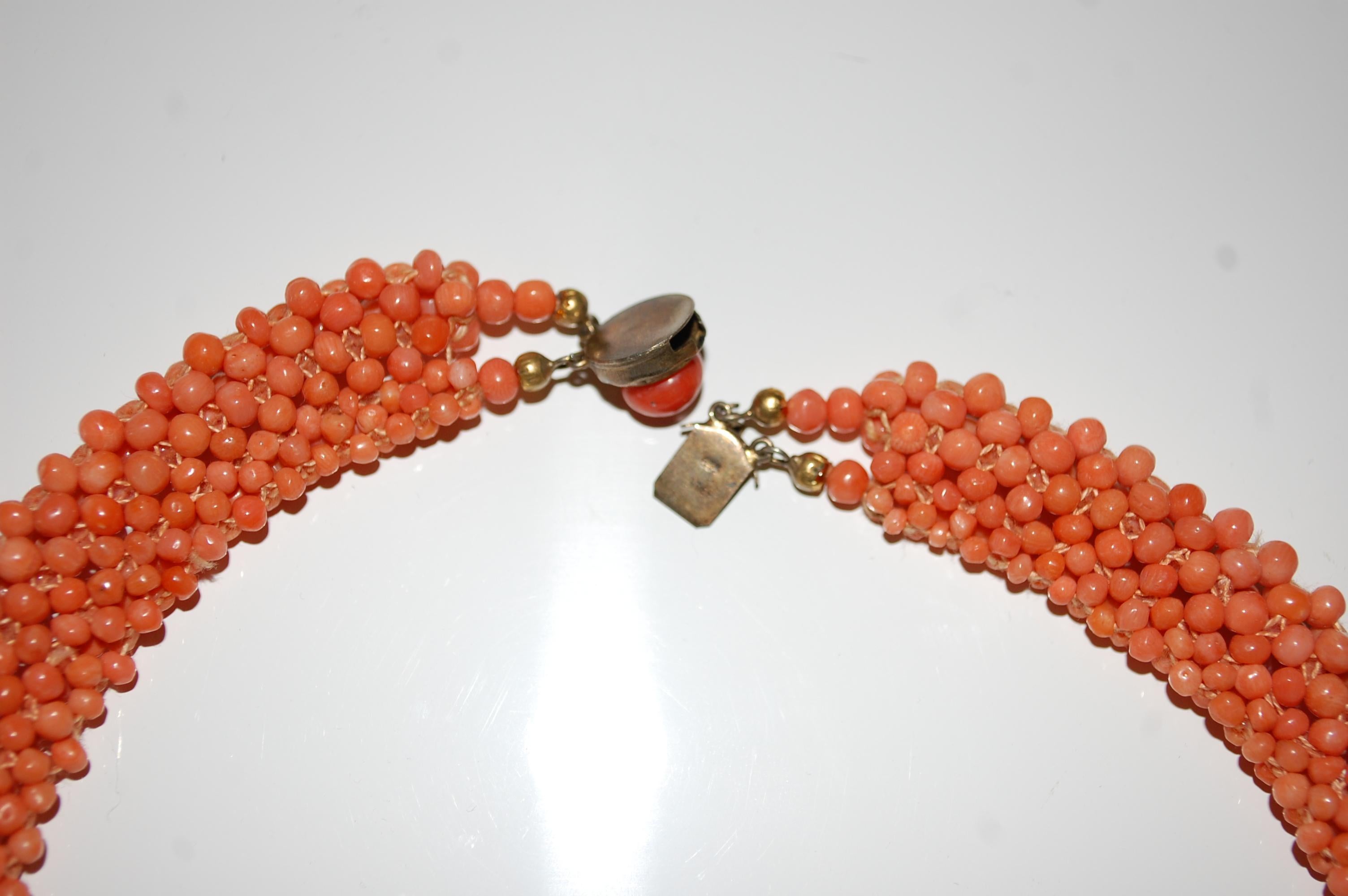 Beautiful and delicate late 19th Century Victorian salmon coral chocker necklace. Round smaller beads braided into two cords wider and narrower entwined together about  0.75 inch width, finished with a gold-plated silver clasp decorated with a