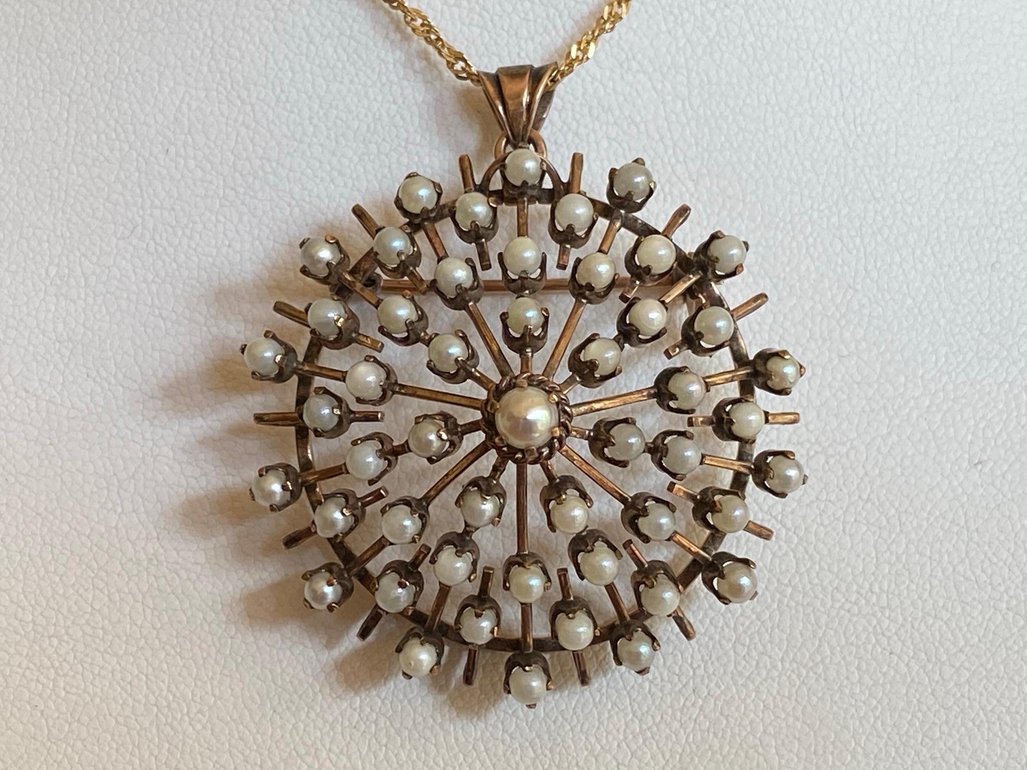 Crafted in the late nineteenth century from 9kt rose gold, this dramatically striking late-Victorian pendant features fifty natural white pearls arrayed over a domed circle with an intricate open work design. The pendant is suspended on a 24 inch