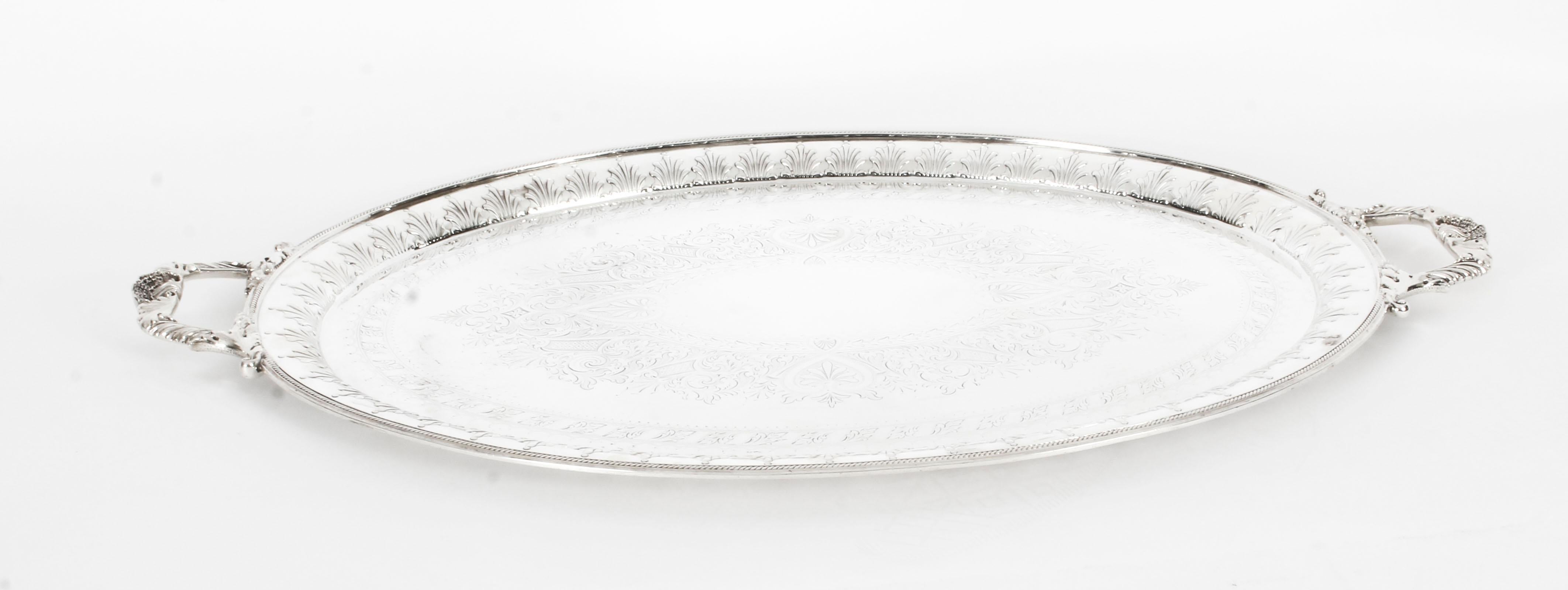 This is an exceptional neoclassical antique English Victorian silver plated tray by the renowned silversmith William Hutton & Sons circa 1890 in date.
 
This large oval silver plated tray features fabulous engraved anthemion, c-scrolls, foliate