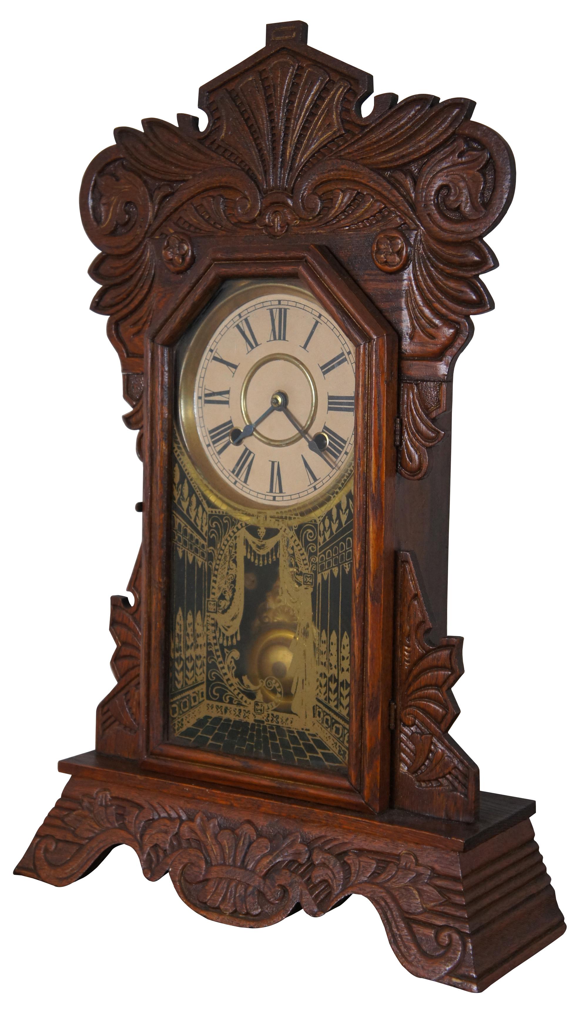 Antique 19th century New Haven “Camden” mantel clock with ornately carved body and reverse painted glass front. Measure: 23