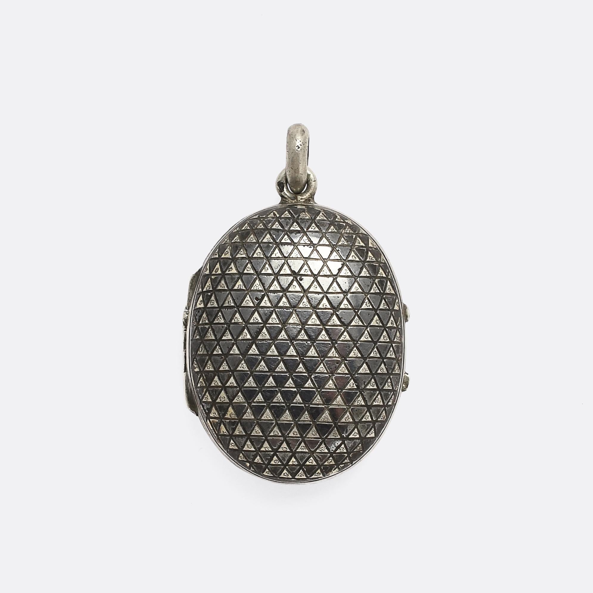 A striking Victorian oval locket crafted in niello silver. Somewhat unusual given how convex the outer case is, coupled with its ever so slightly diminutive size. The surface sports rows of alternating black and silver triangles to create a pleasing