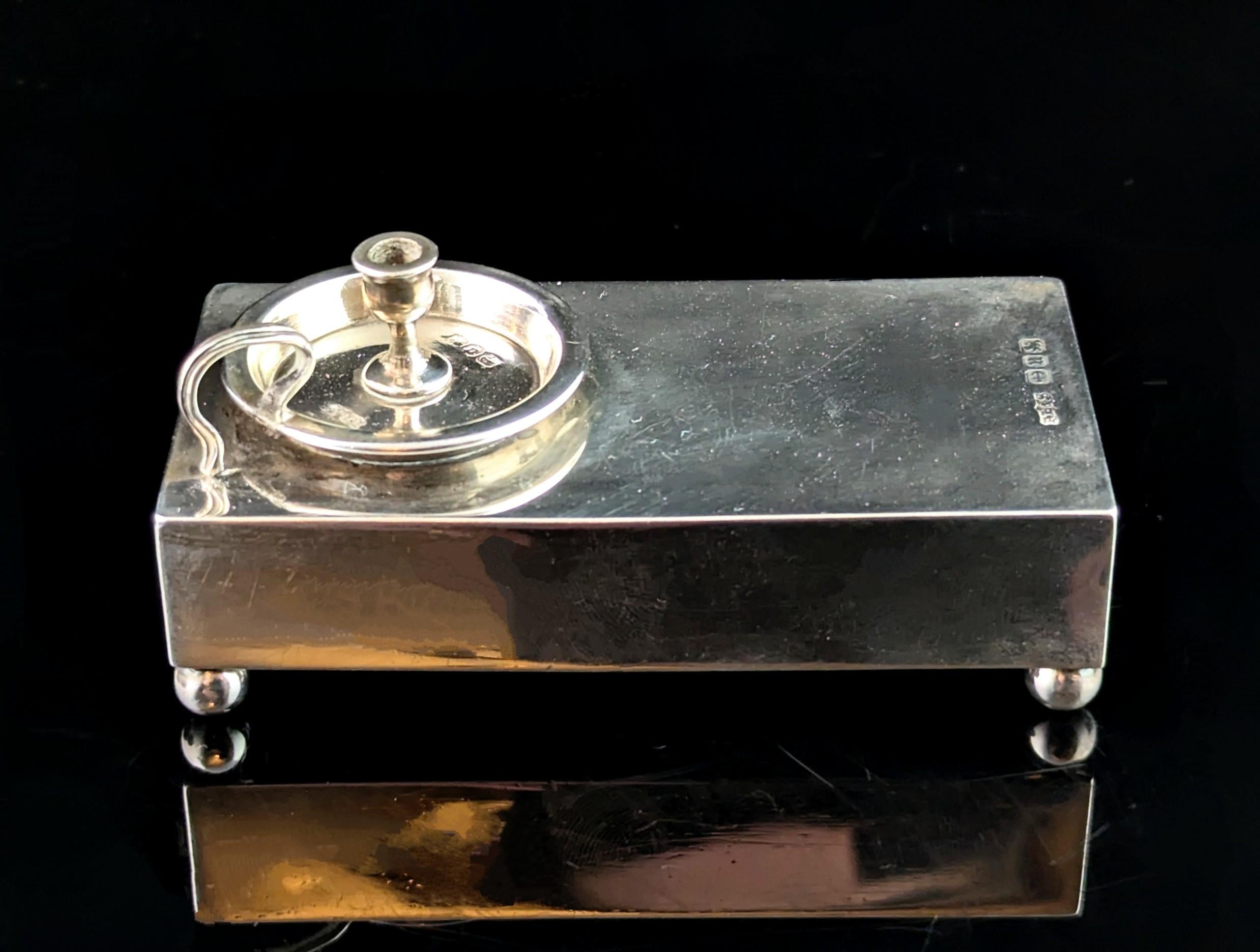 A fantastic antique novelty silver matchbook cover.

Very well made in cool sterling silver, it is large sized matchbook cover, the box of matches sliding into the recess at the front.

It stands on four stylish globe feet and the top is adorned by