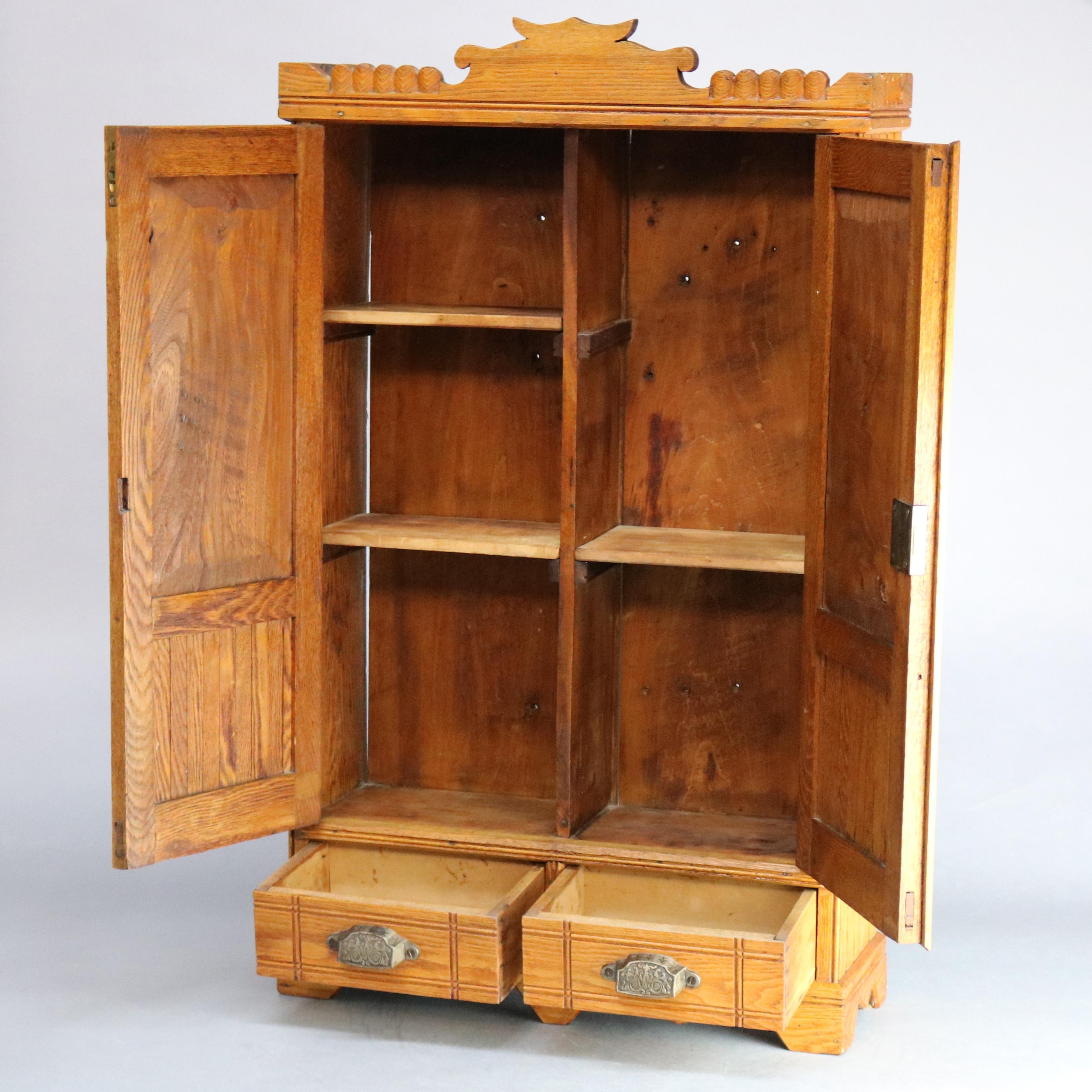 An antique Victorian medicine wall cabinet offers oak construction with shaped crest over beadboard cabinet with double paneled doors having incised bordering and opening to shelved interior over double lower drawers, c1890

Measures: 33.5
