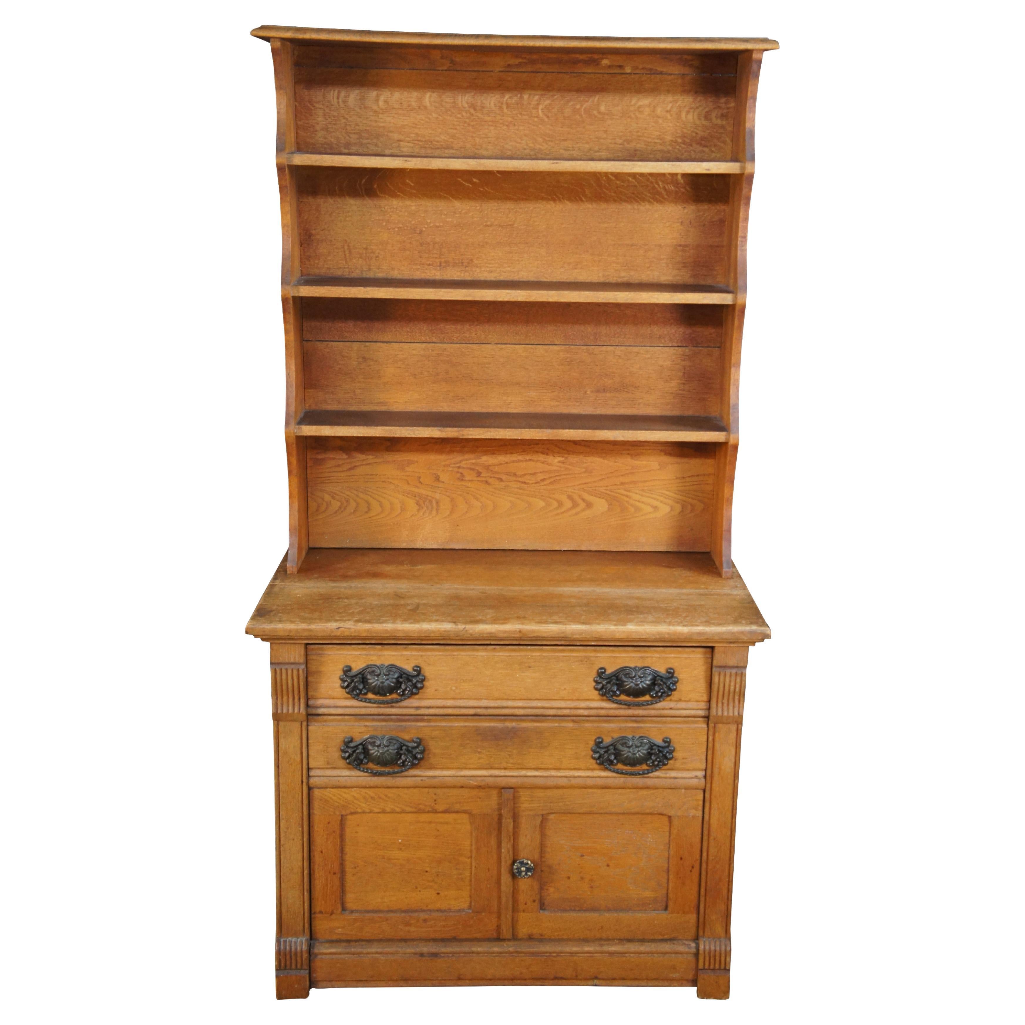 Antique Victorian stepback bookcase hutch.  Made of oak featuring an upper bookshelf supported by lower stand on castors with two drawers and a cabinet.

Dimensions:
18