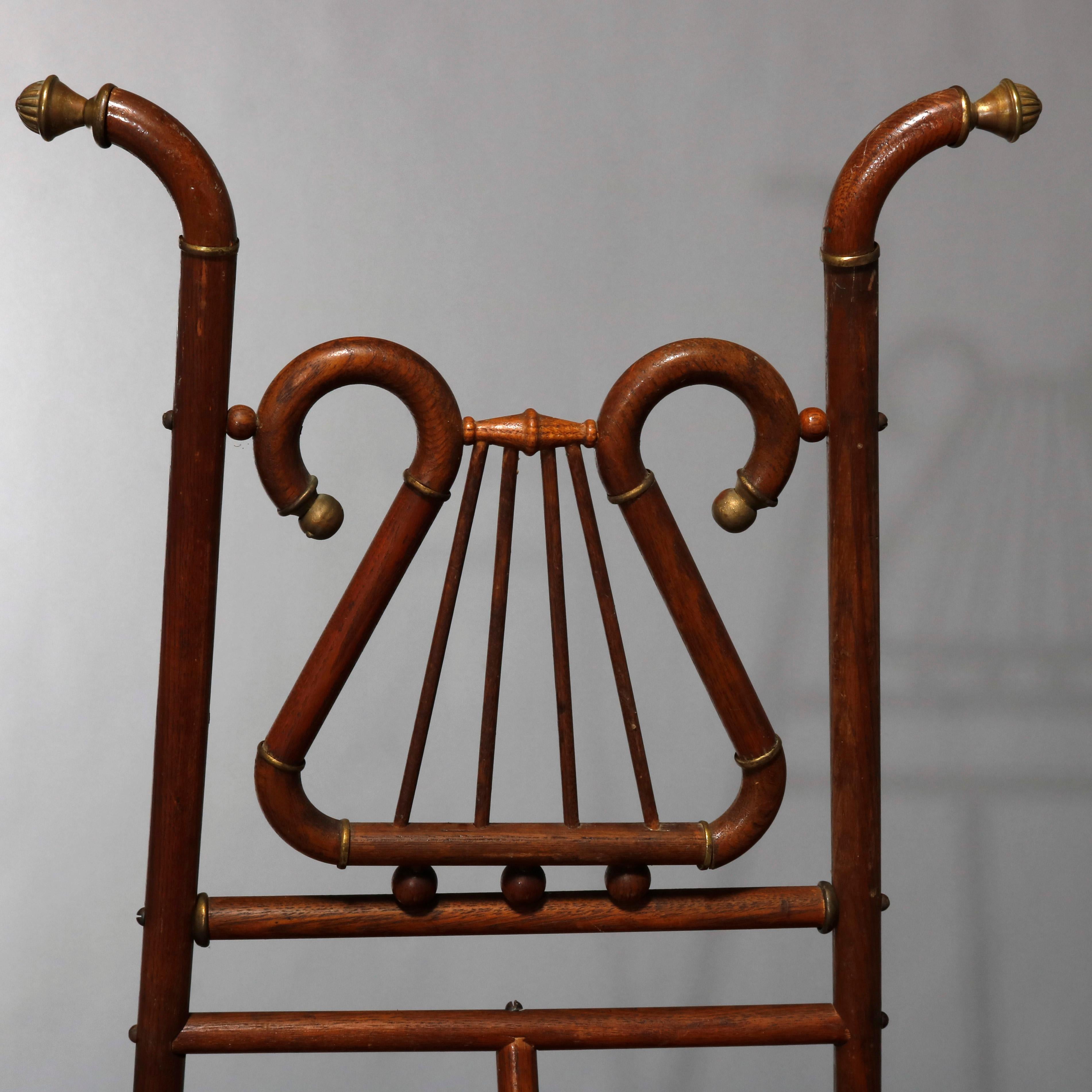 An antique Victorian art display easel offers oak stick and ball construction with lyre form crest, circa 1900.

Measures: 67.5