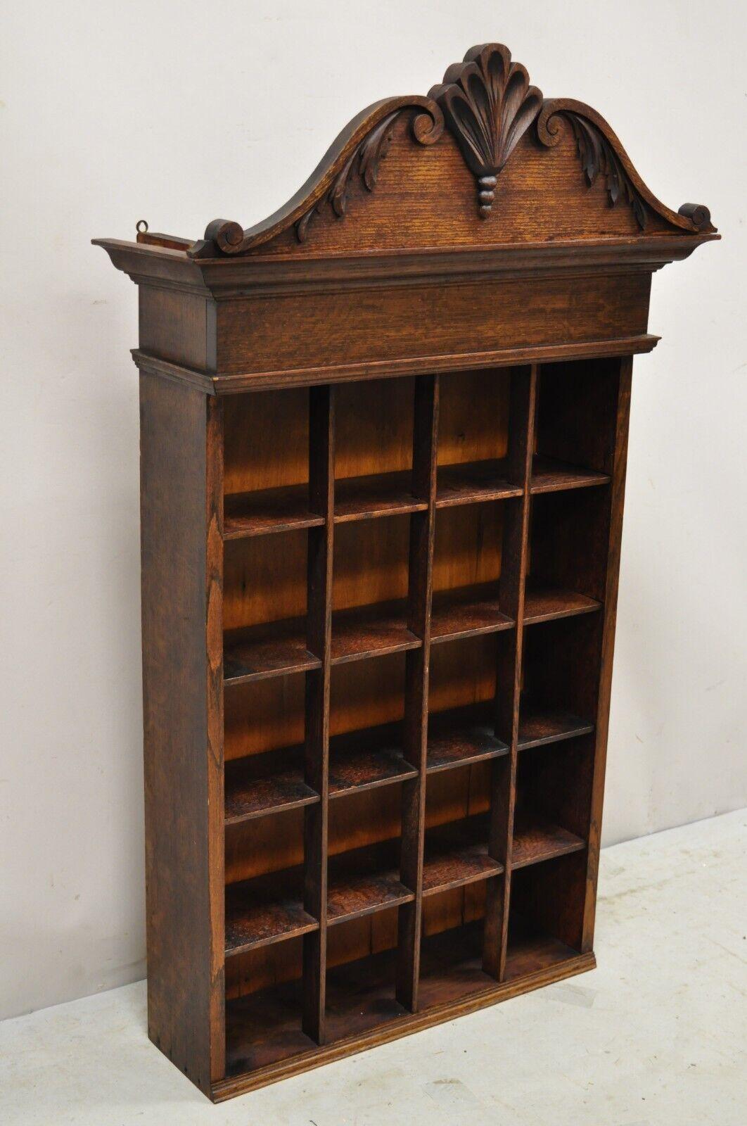 Antique Victorian oak wood 20 section wall display cabinet shaving mug rack. Item features a nicely carved pediment, 20 cubby holes, beautiful wood grain, very nice antique item, quality American craftsmanship, great style and form. circa 19th
