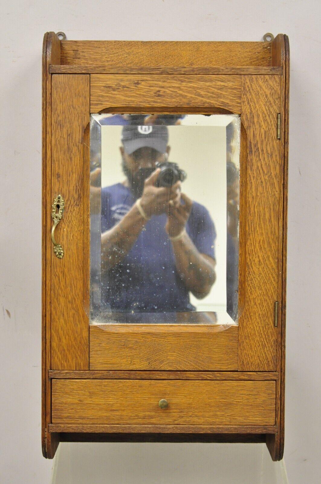 Antique Victorian Oak Wood and Mirror Hanging Bathroom Medicine Cabinet. Item features beveled glass mirror, solid wood construction, beautiful wood grain, no key, but unlocked, 1 drawer, very nice antique item, great style and form. Circa Early