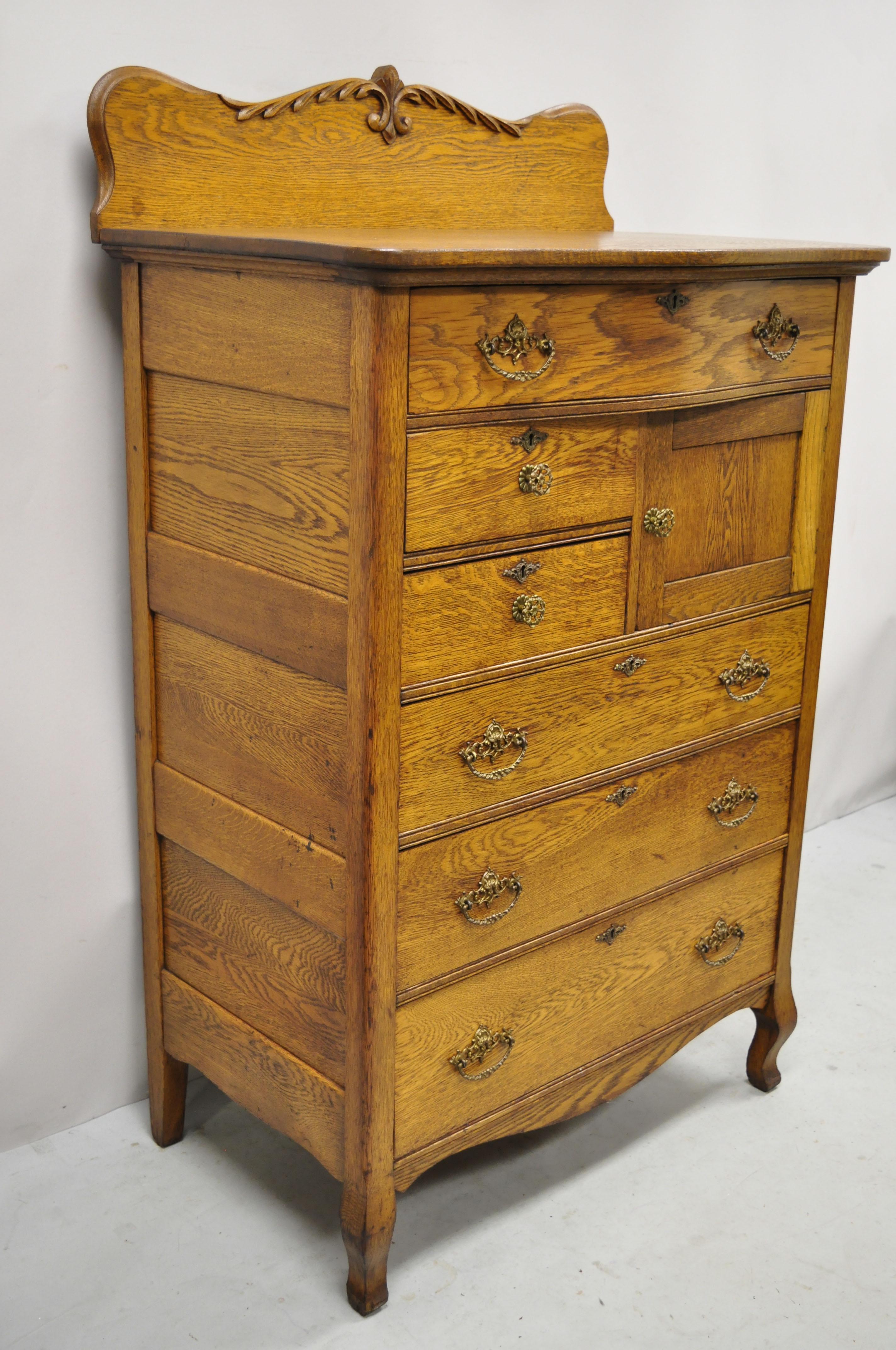 Antique Victorian Oak wood tall chest dresser cabinet with carved backsplash. Item features carved backsplash, 1 swing door, no key, but unlocked, 6 dovetailed drawers, very nice antique item, quality American craftsmanship, great style and form.