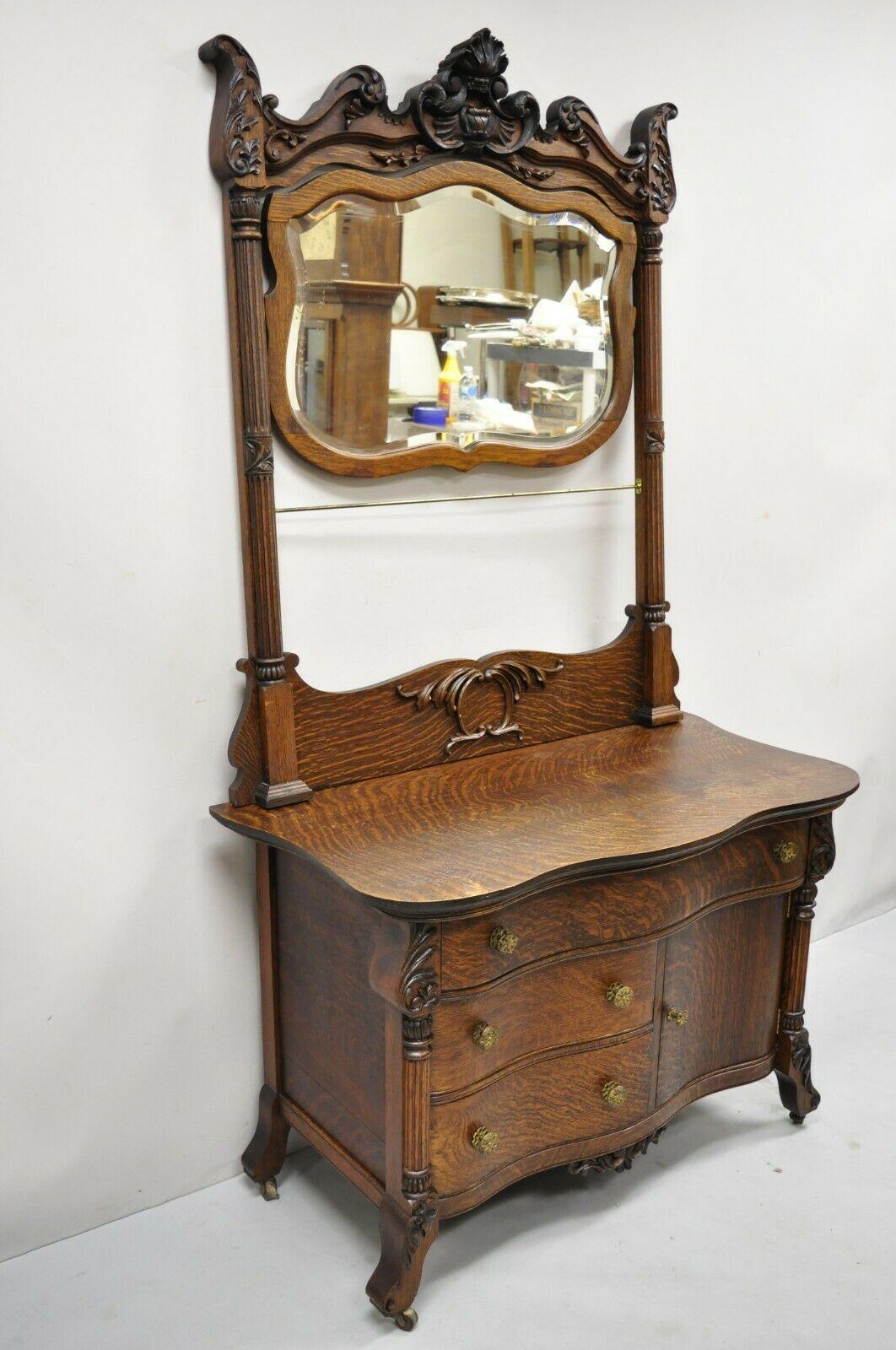 Antique Victorian oak wood washstand princess dresser vanity with shaving mirror. Item features rolling casters, serpentine front, beautiful wood grain, nicely carved details, 1 swing door, 3 drawers, solid brass hardware, very nice antique item,
