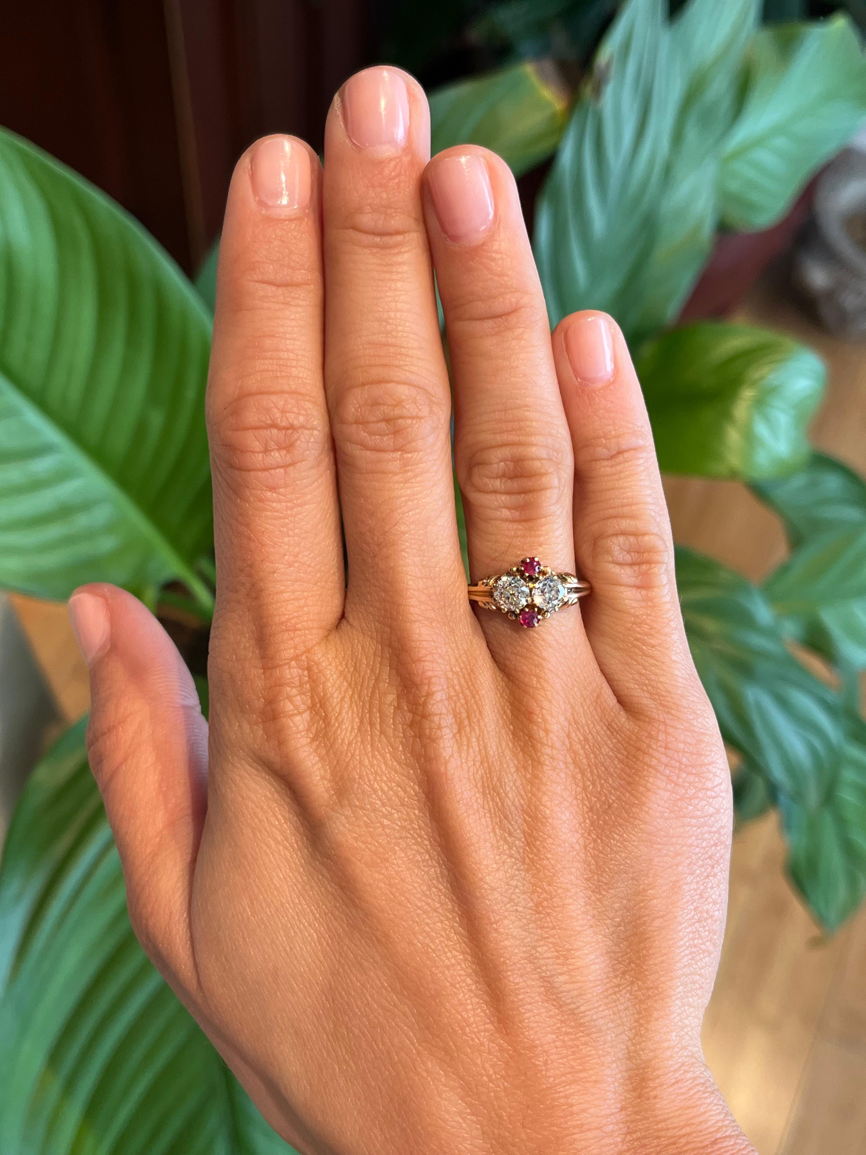Dating back to circa 1900, this Victorian-era ring is a stunning example of antique craftsmanship. Two old mine cut diamonds and two rubies adorn the ornate 14K yellow gold band, detailed with romantic scrollwork. A timeless heirloom bridging