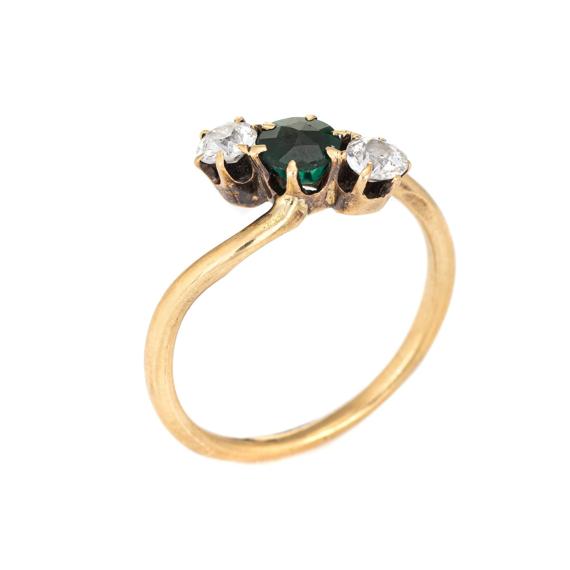 Finely detailed antique Victorian ring (circa 1880s to 1900s) crafted in 14 karat yellow gold. 

Two estimated 0.20 carat old mine cut diamonds total an estimated 0.40 carats (estimated at I-J color and I1-2 clarity). One estimated 0.25 carat green