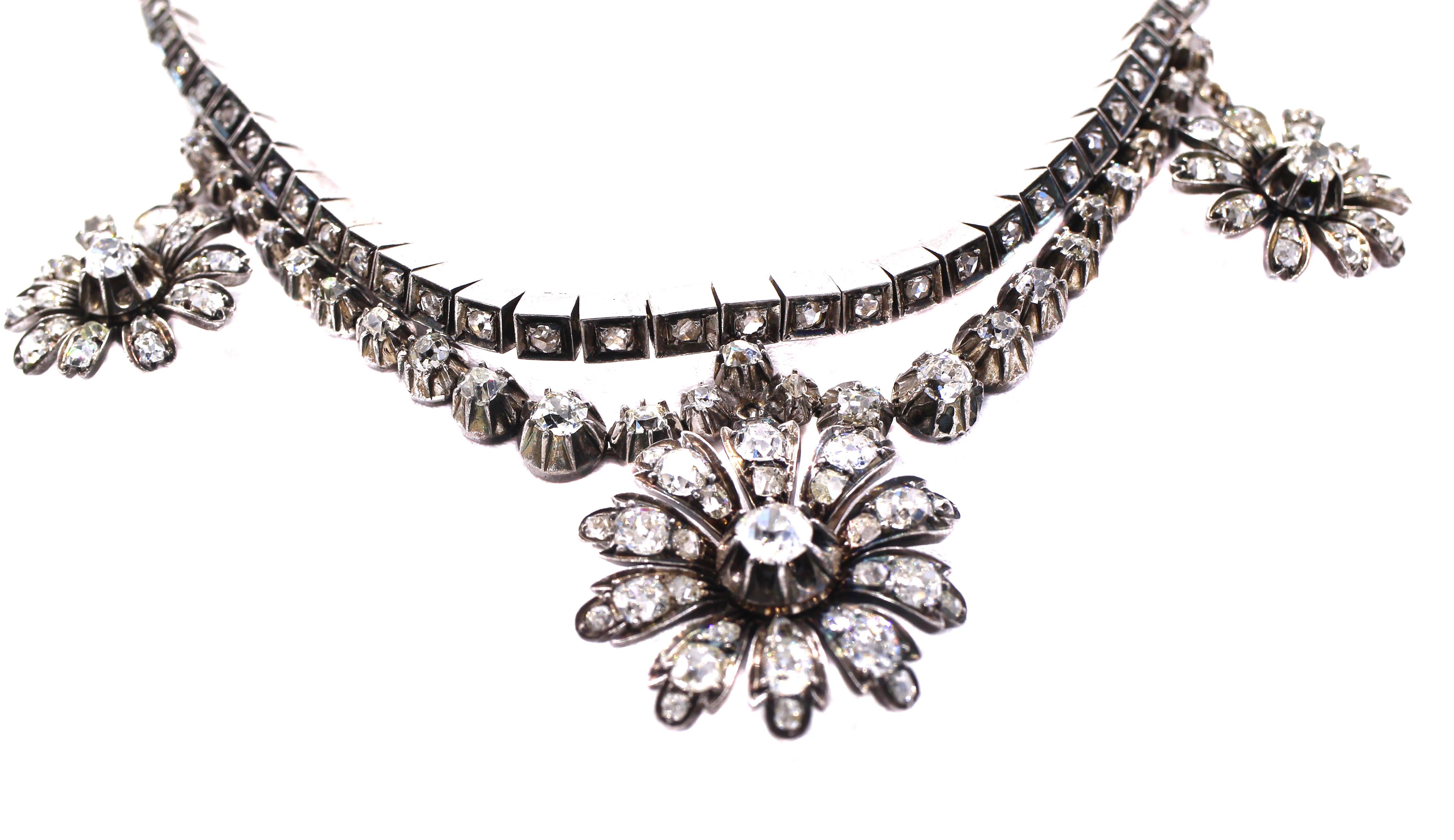 Beautifully designed and masterfully handcrafted in silver topped gold this lovely Victorian necklace from ca 1870 is a special piece of period jewelry. The necklace is set with small rose cut diamonds in boxes of silver topped gold with a second