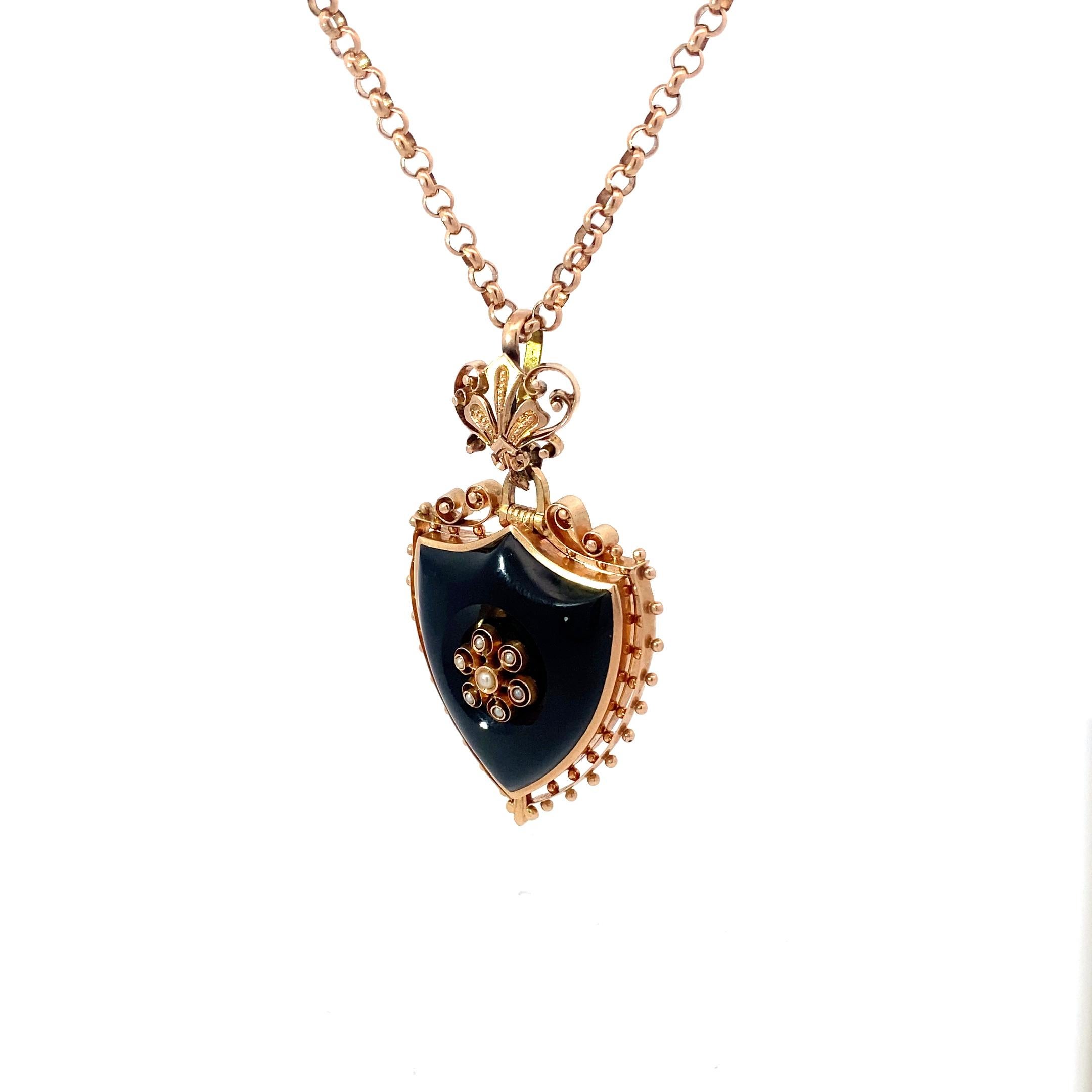 Wonderfully large carved onyx locket in the shape of a shield. The carved onyx is wrapped in luxe 14k gold detailing, including an ornate filagree bail affixing it to an 18in round link chain. The gold detailing and the chain has a subtle rosy