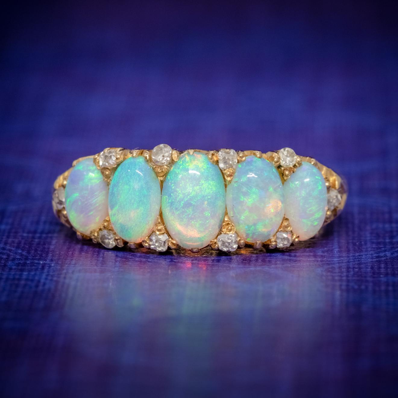 A striking Antique 18ct Gold Opal ring dating from the late-Victorian era Circa 1880. The piece is adorned with five fabulous natural Opals accompanied by ten twinkling Diamonds nestled in-between.   

The Opals are a kaleidoscope of vibrant colours