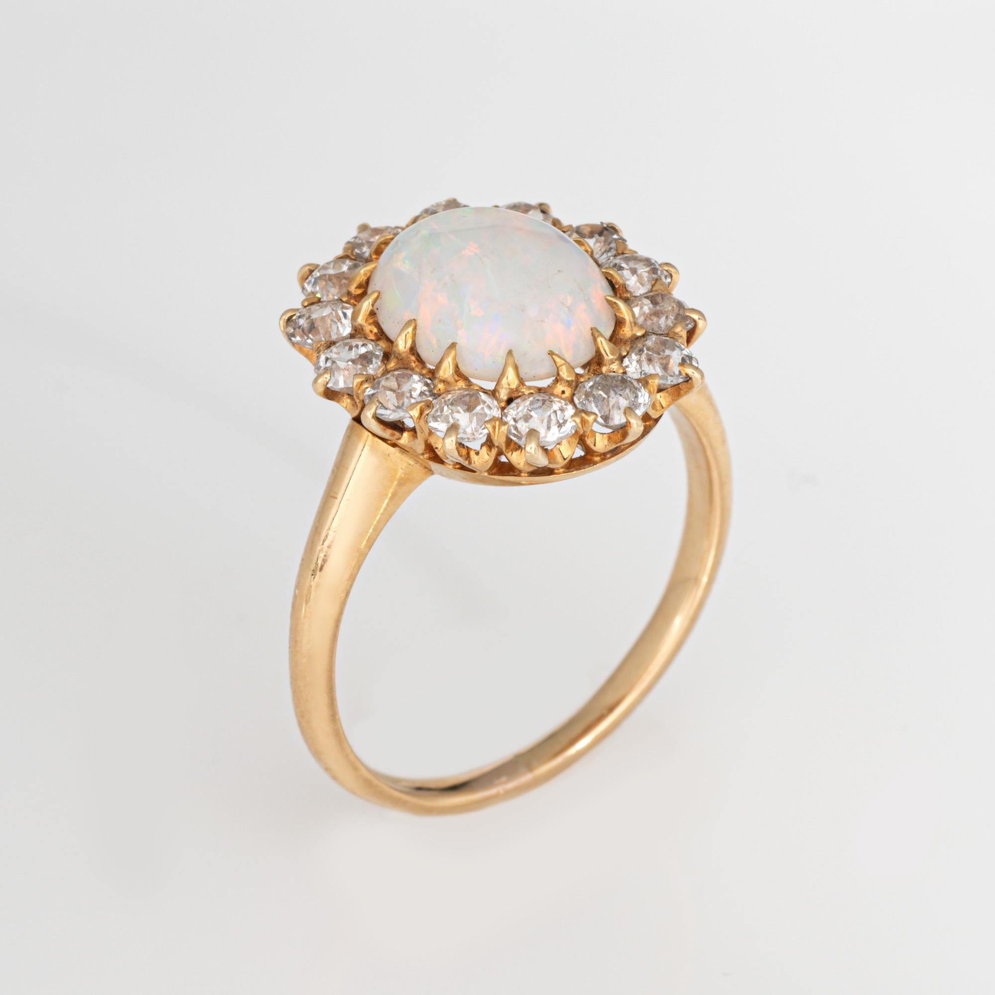 Stylish and finely detailed opal & diamond ring crafted in 18 karat yellow gold (circa 1880s to 1900s).

Cabochon cut opal measures 10mm x 8mm (estimated at 2 carats). Old mine cut diamonds total an estimated 1 carat (estimated at J-K color and