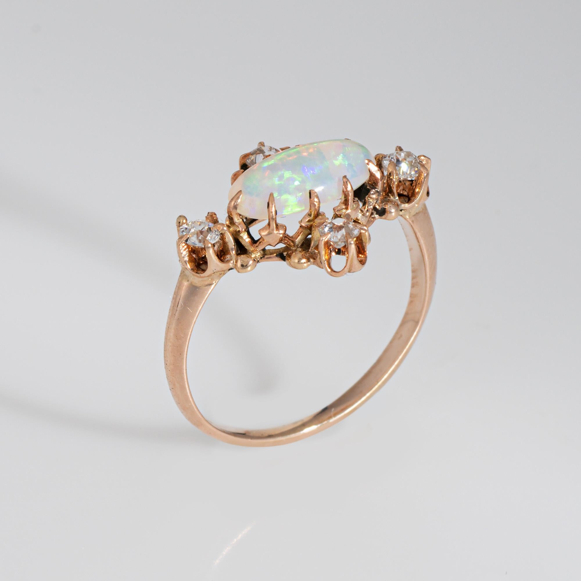 Stylish antique Victorian era ring (circa 1880s to 1900s), crafted in 14 karat yellow gold.

Cabochon cut opal measures 9mm x 5mm, accented with 4 estimated 0.05 carat old mine cut diamonds. The total diamond weight is estimated at 0.20 carats