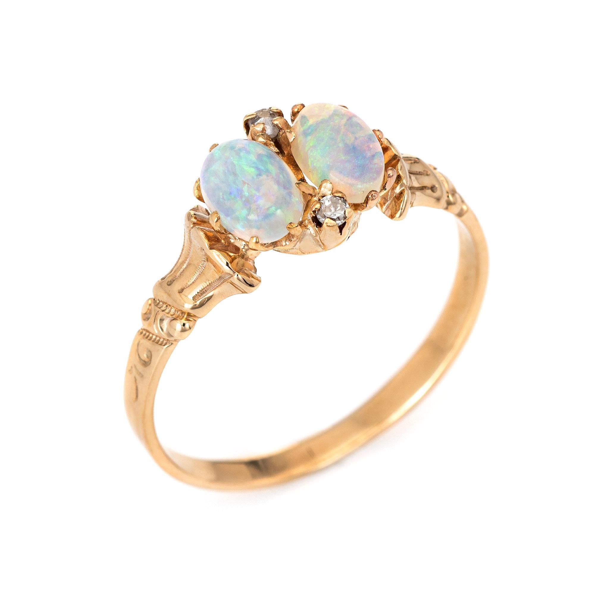 Finely detailed antique Victorian ring (circa 1880s to 1900s) crafted in 10 karat yellow gold. 

Two opals measure 7mm x 4.25mm (estimated at 0.50 carats each - 1 carat total estimated weight). Two old rose cut diamonds are estimated at 0.02 carats