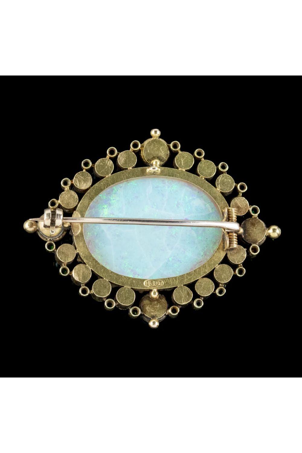 A magnificent antique late Victorian brooch claw set with an enormous natural opal cabochon in the centre, weighing an impressive 25 carats (approx.) It’s haloed by eighteen bright pearls and an array of rich green garnets that chase around the