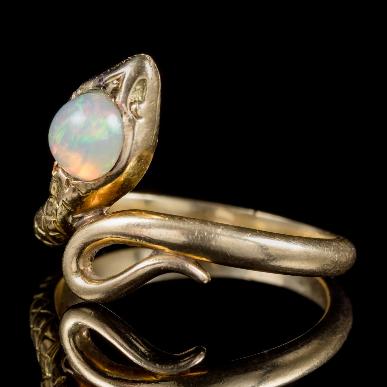 A wonderful antique Victorian 18ct Yellow Gold snake ring crowned with a beautiful 0.75ct natural Opal. Serpent jewellery was popular in Victorian times and represented love, loyalty and friendship. The lovely Opal is a kaleidoscope of rainbow