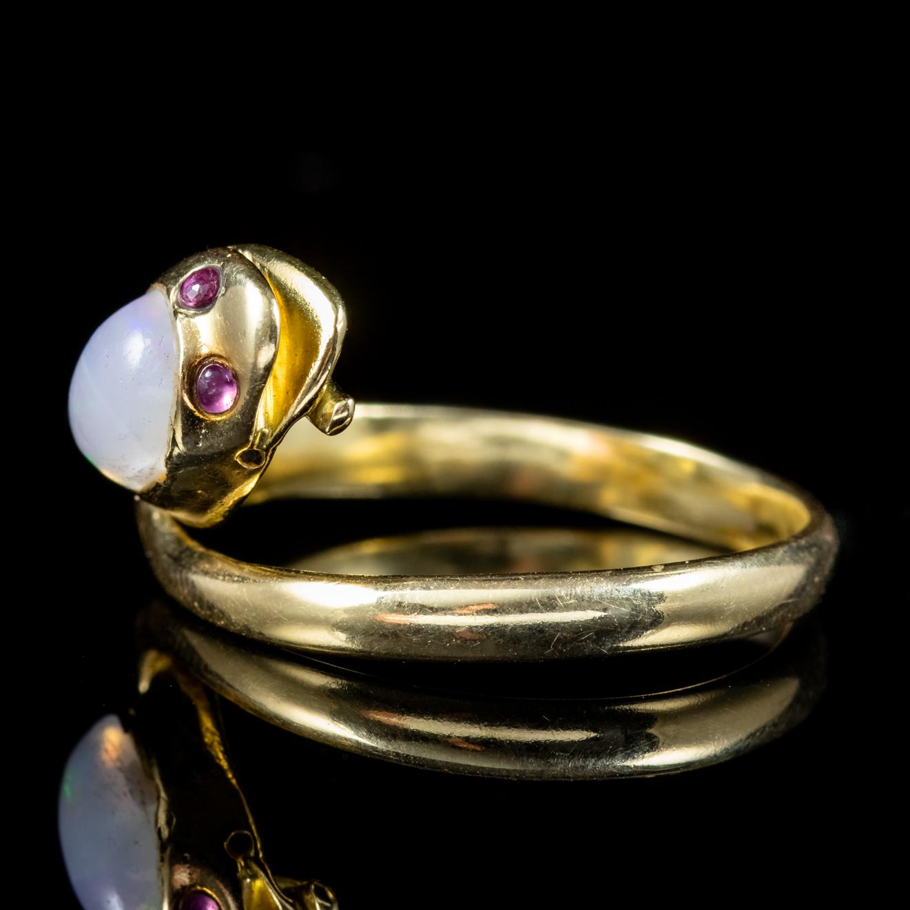 A fabulous antique Victorian snake ring modelled in 18ct Yellow Gold and set with red Ruby eyes and crowned with a beautiful natural Opal which is approx. 0.90ct. 

Serpent jewellery was popular in Victorian times and represented love, loyalty and