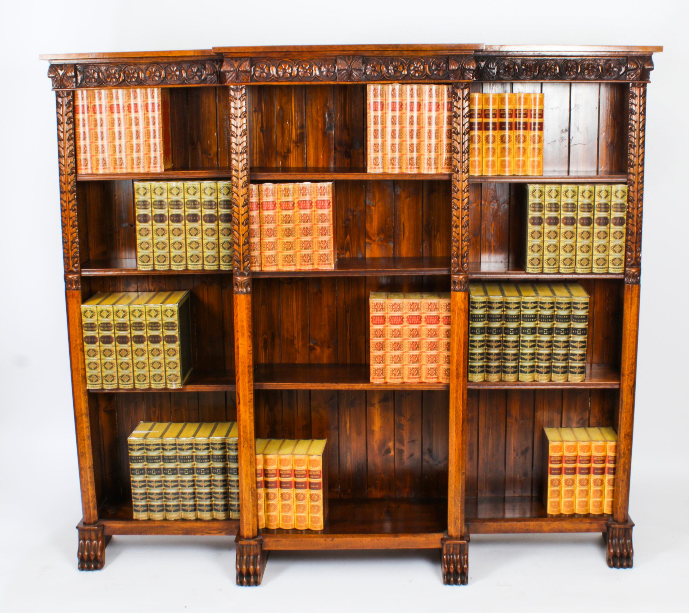 This is a beautiful antique Victorian oak open breakfront bookcase, Circa 1870 in date.
 
The breakfront top above a frieze, the solid oak superbly carved with rosettes, above three banks of open bookshelves enclosing fourteen adjustable shelves,