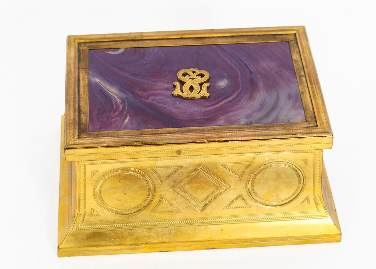 This is a truly magnificent antique Victorian ormolu and glass jewellery casket, circa 1870 in date.
 
This exceptional casket is rectangular in shape and features concave sides with engraved with geometrics panels. The lift-up art Royal Purple