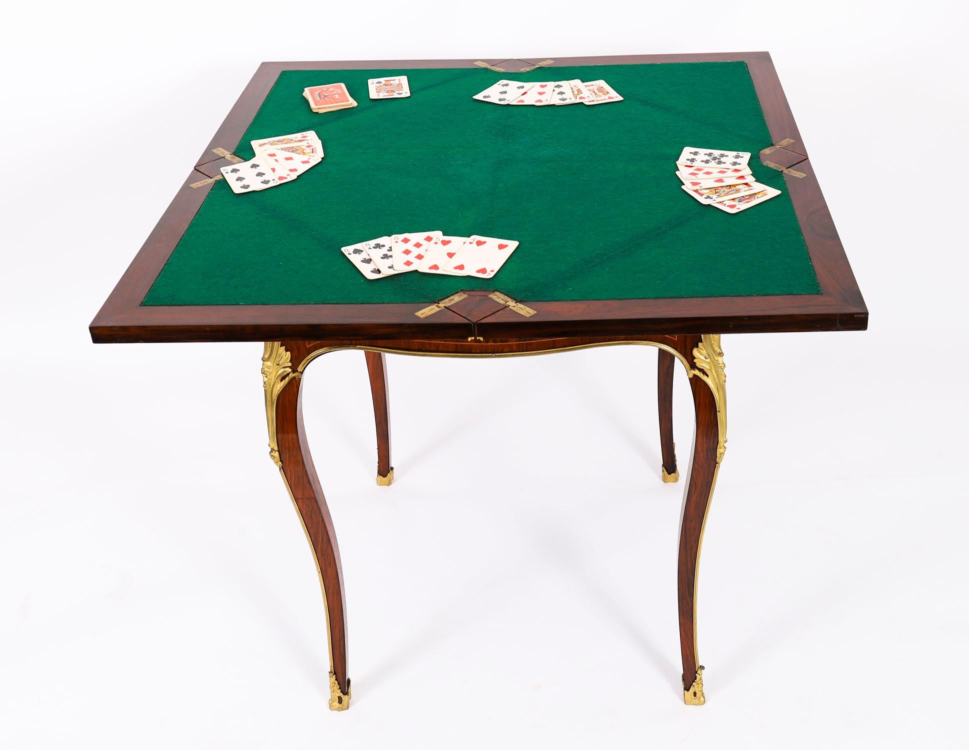 This is a beautiful antique Victorian ormolu mounted envelope card table, circa 1880 in date.

The card table is made from superb quality Gonçalo Alves, has the most striking musical instrument marquetry decoration with superb gilded ormolu