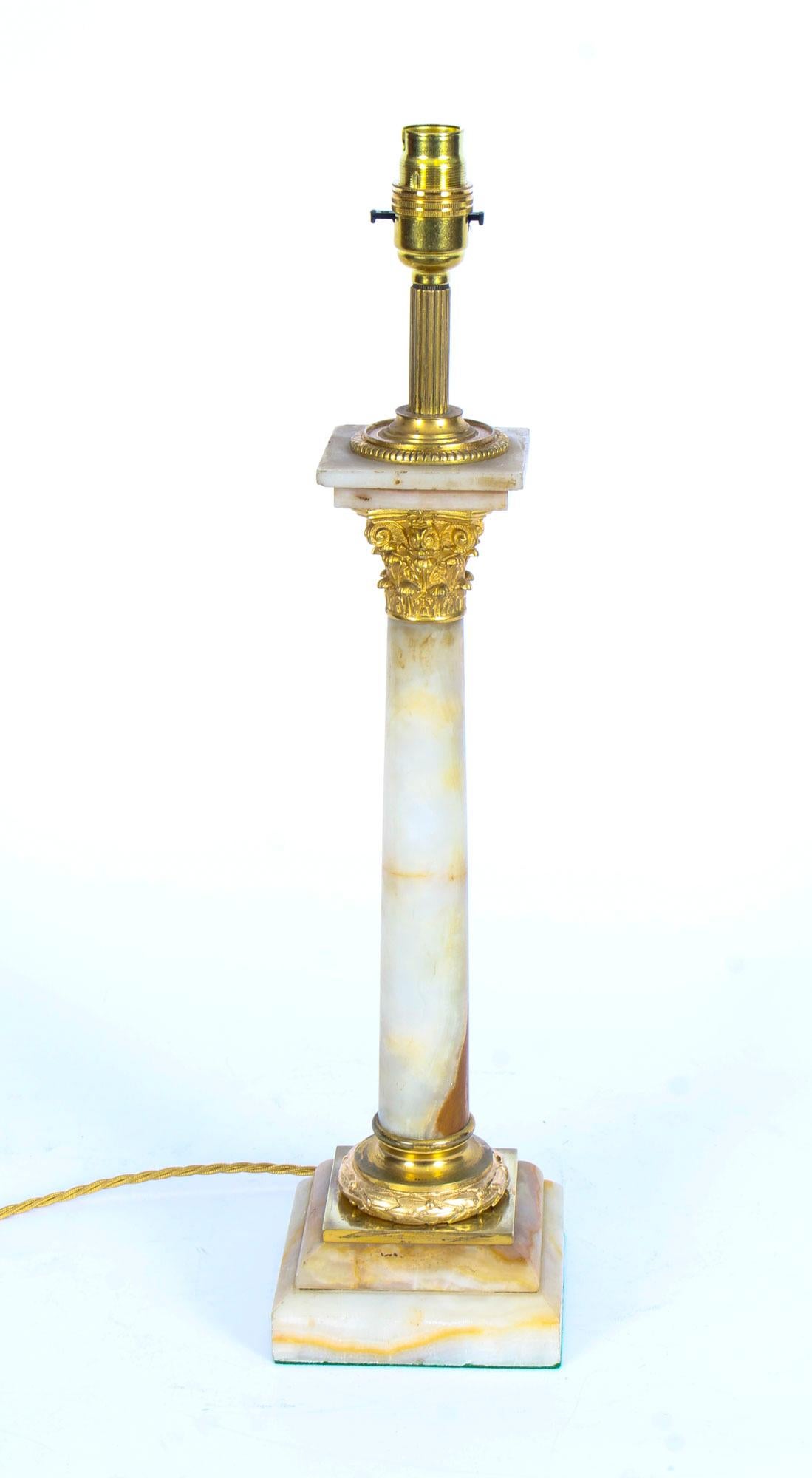 This is a splendid antique late Victorian ormolu mounted onyx Corinthian column table lamp now converted to electricity, circa 1880 in date.

This opulent antique table lamp features a finely cast ormolu Corinthian Capital decorated above a striking