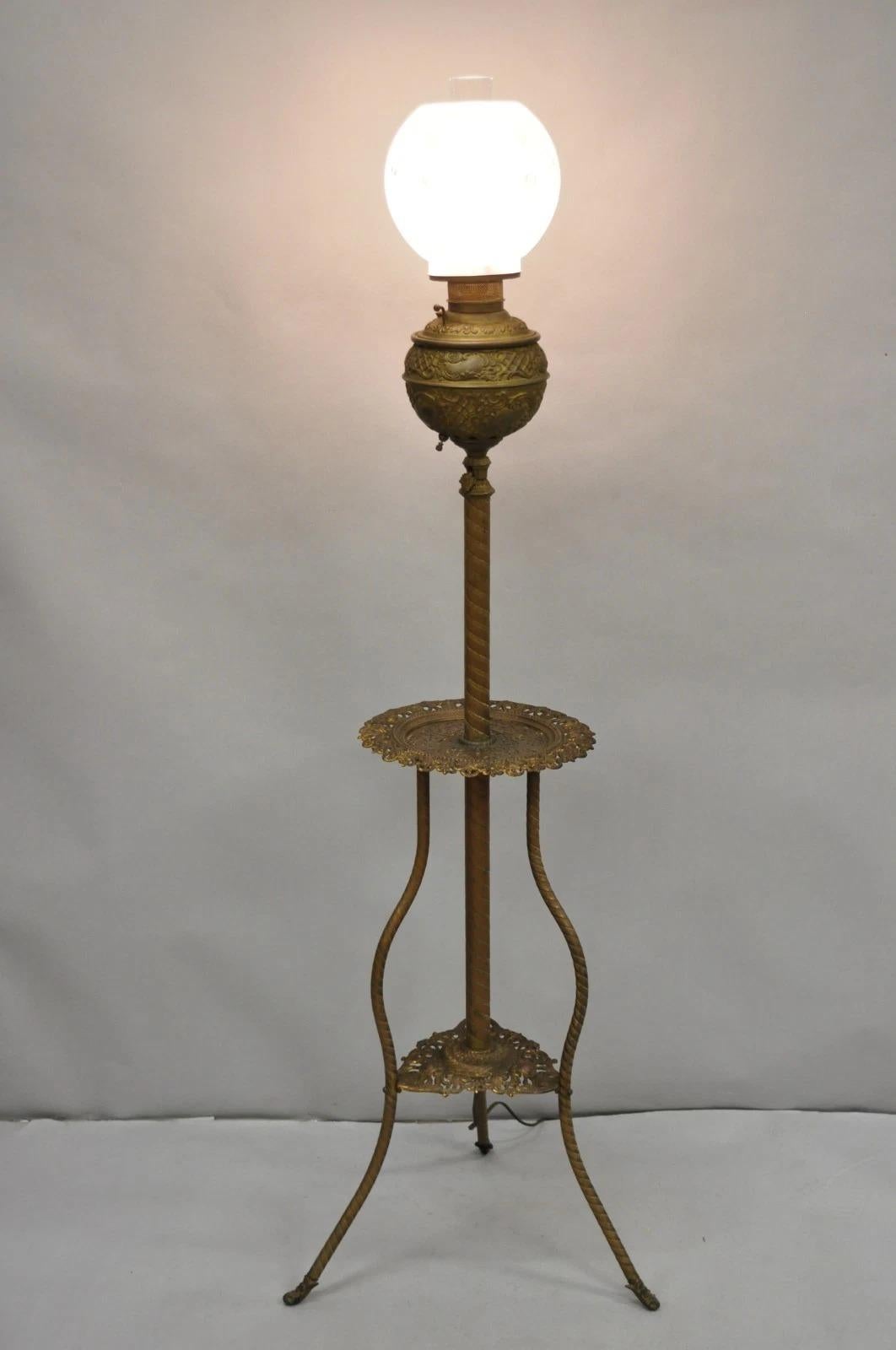 Please message us with your zip code to request a more reasonable domestic U.S. shipping quote.

Antique Victorian Ornate Brass Converted Oil Lamp Piano Parlor Floor Lamp with Round Surface and Glass Shades. Circa Late 19th Century. Measurements:
