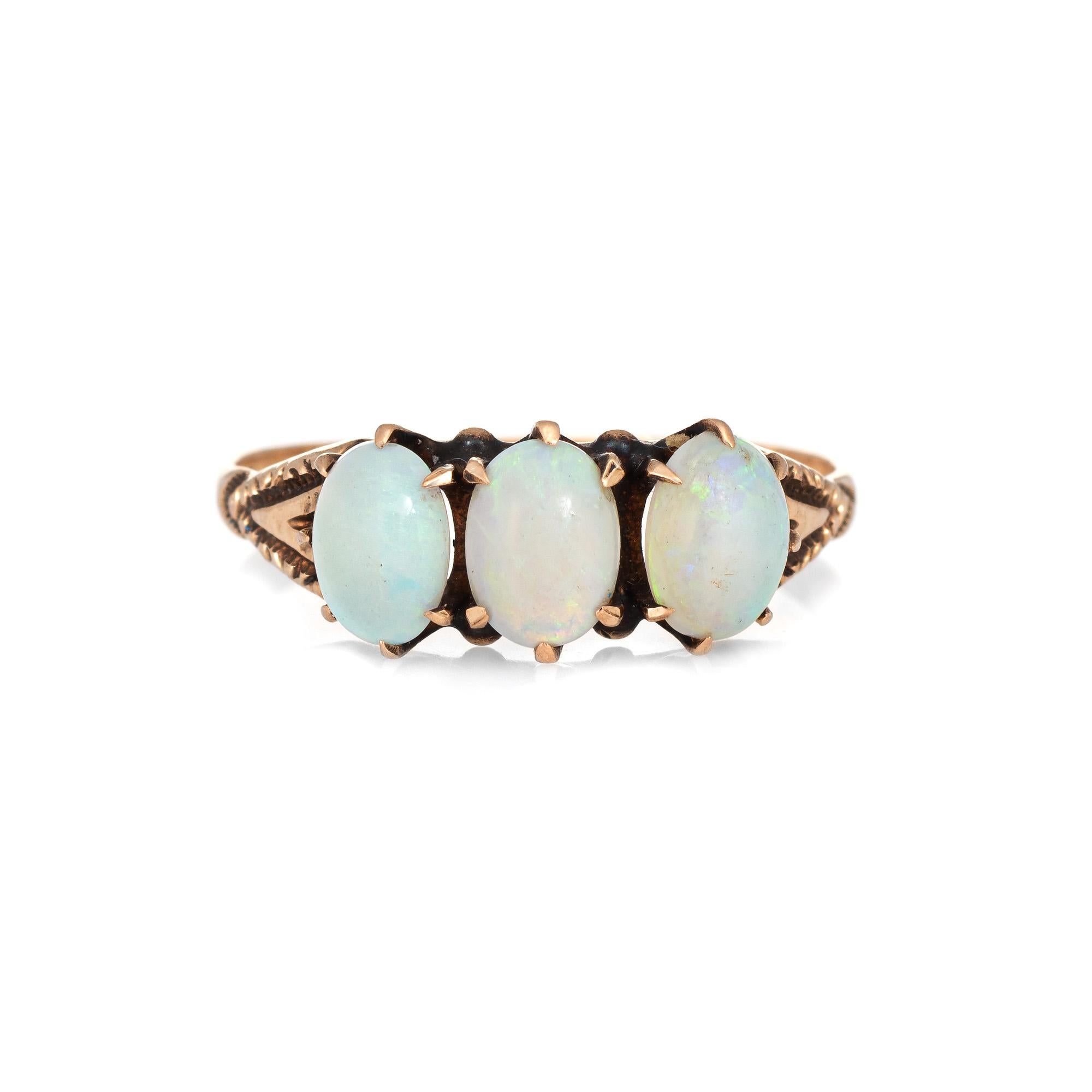Finely detailed antique Victorian era three stone opal ring (circa 1880s to 1900s), crafted in 14 karat yellow gold.

The ring is made by Ostby & Barton, one of the most well known jewelry manufacturers of the period. The firm was founded in 1879