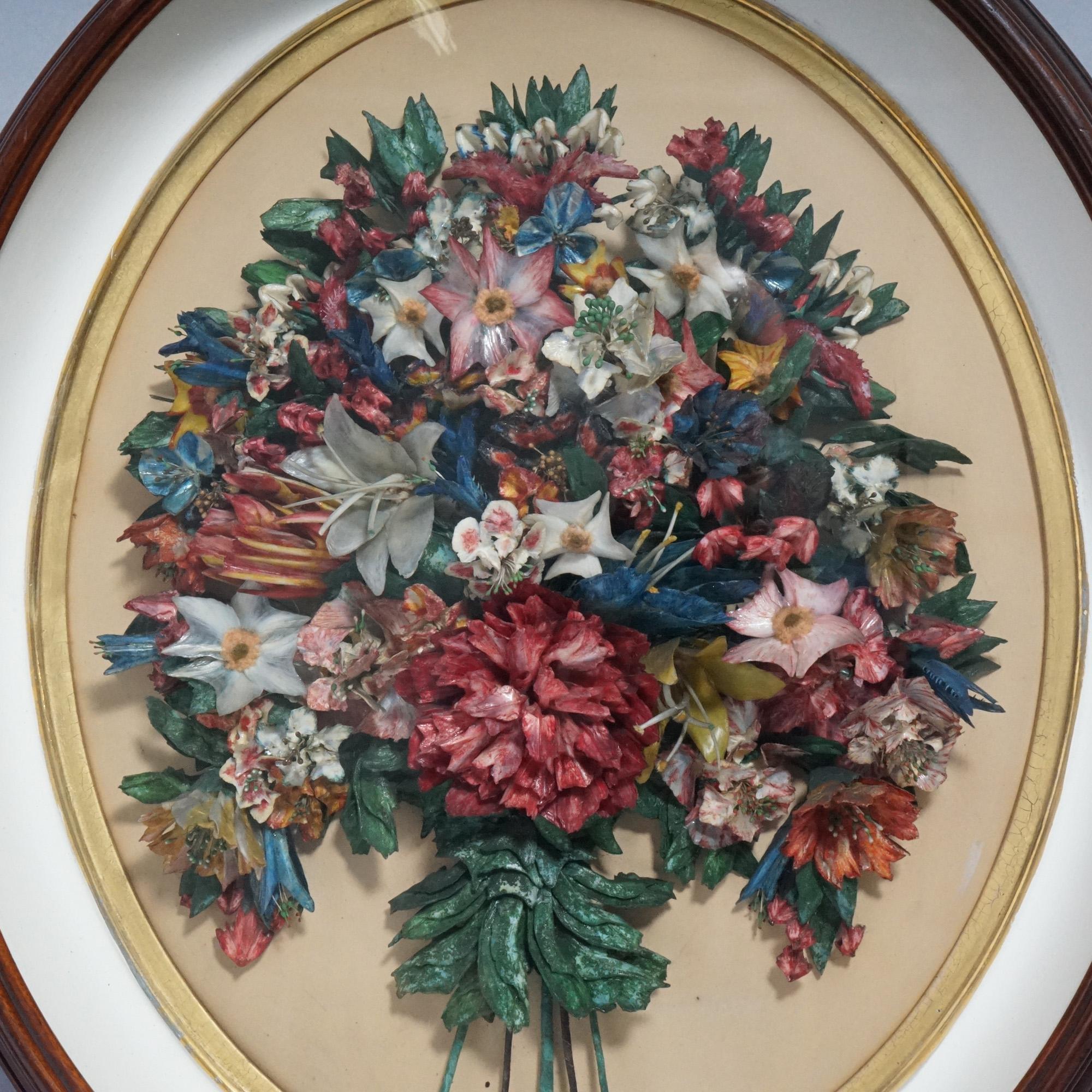 An antique Victorian shadow box offers oval mahogany frame with interior wax floral bouquet sculpture, 19th century.

Measures- 26.5''H x 22.25''W x 3.5''D.