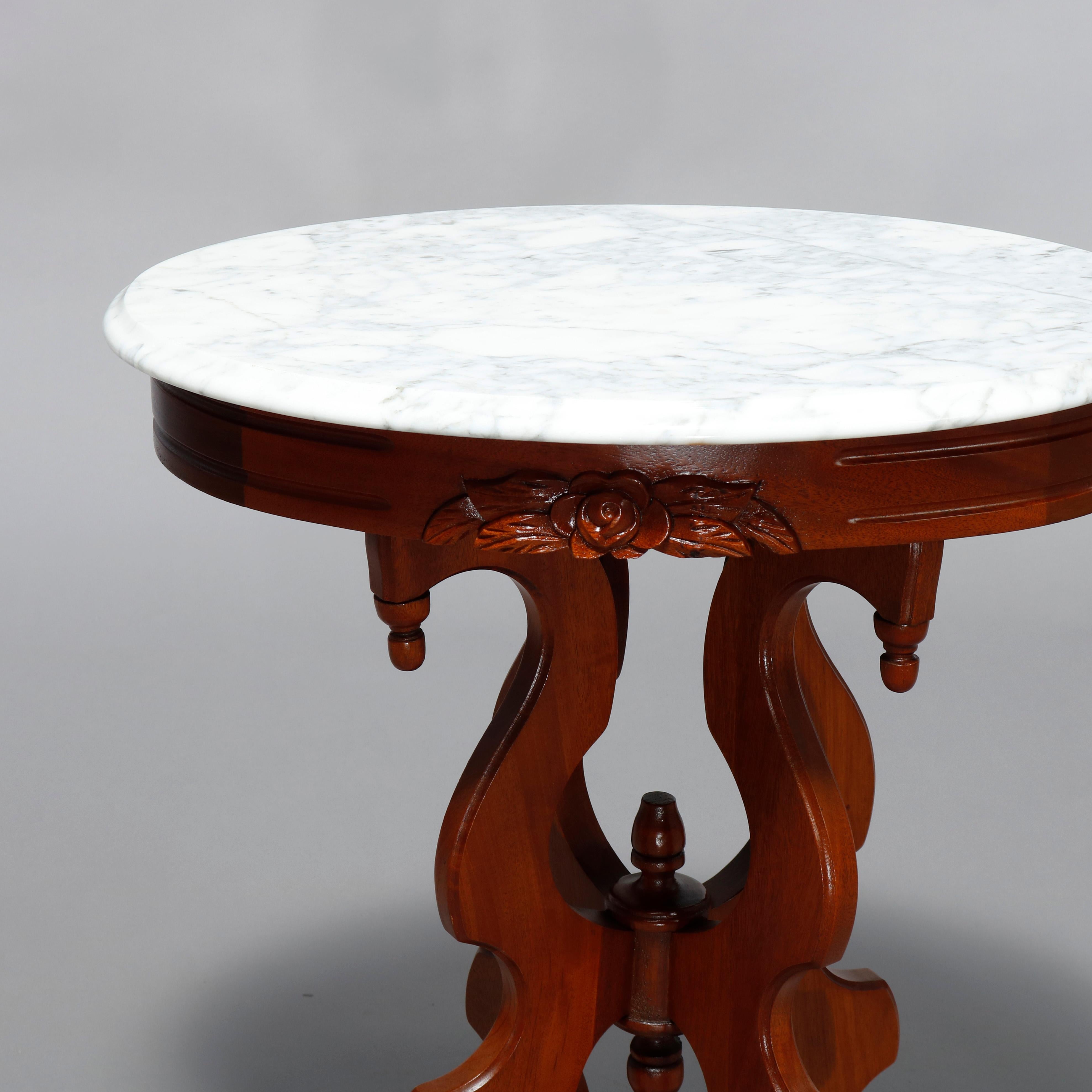 An antique Victorian side stand offers oval form with beveled marble top over scroll form walnut base having drop finials, 20th century

Measures: 26.75