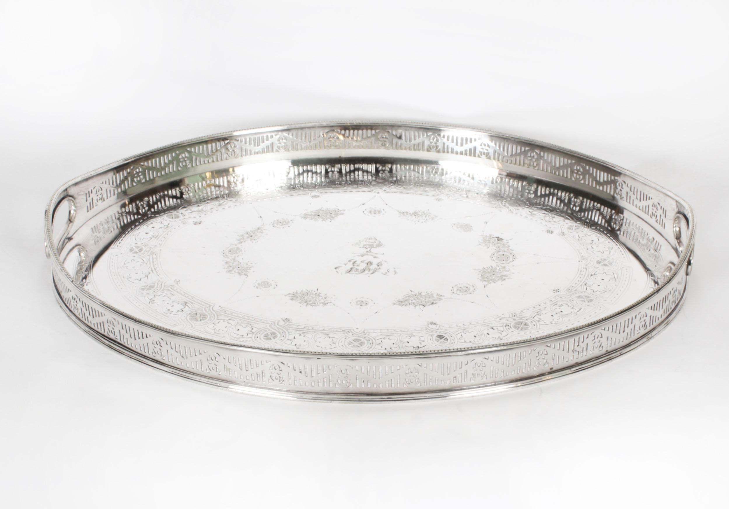 This is a large beautiful antique English Victorian Neo- Classical oval silver-plated twin handled gallery tray, circa 1890 in date.

This stunning tray features elegant engraved c-scrolls and foliate and floral decoration with Neo Classical fluting