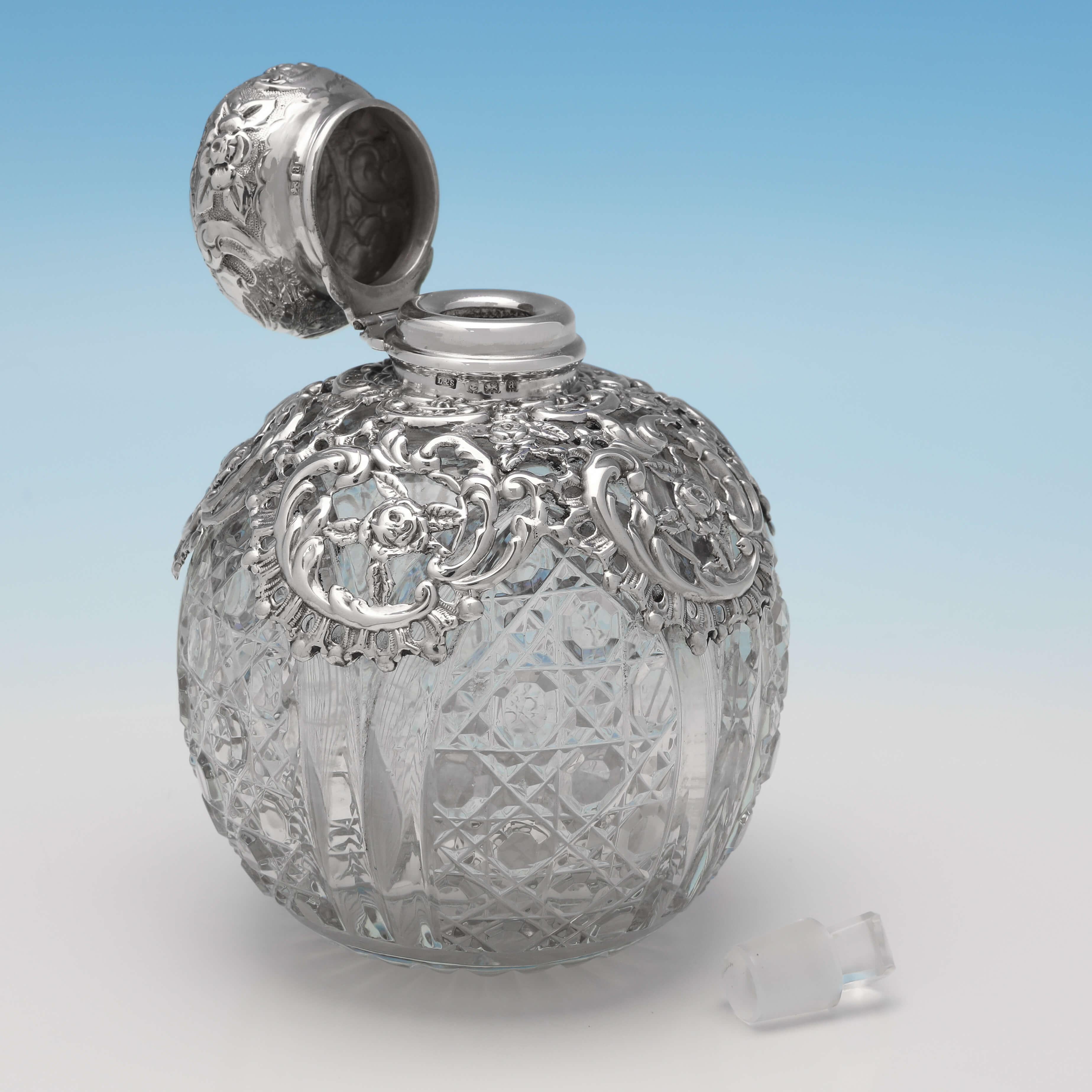 Hallmarked in Birmingham in 1900 by Levi & Salaman, this attractive, Antique Sterling Silver Scent Bottle, is ornate in design, with a hobnail cut glass body, and decorative mount and lid. The scent bottle measures 4.5