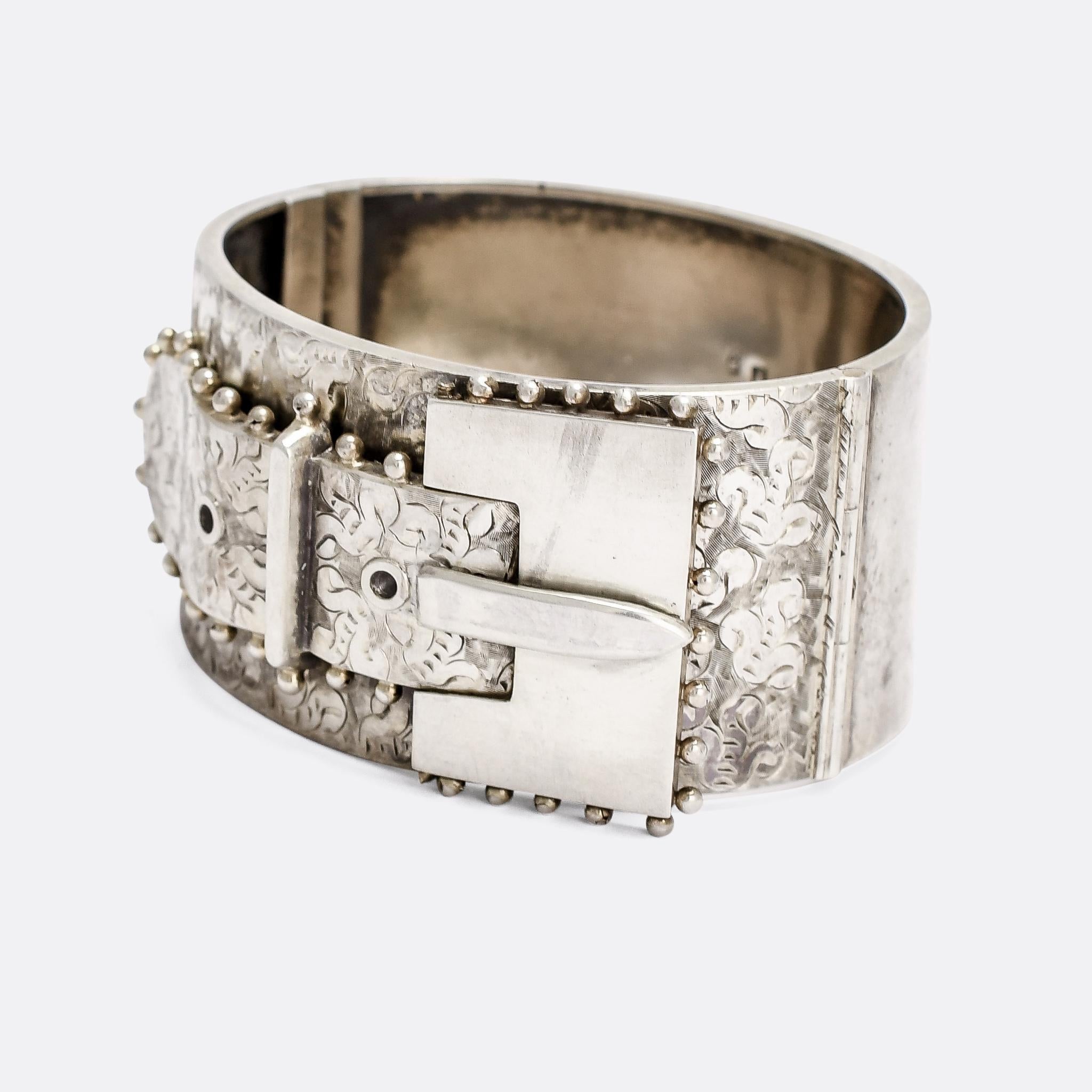 A big and bold antique silver cuff bangle dating from the latter half of the 19th Century. It's intricately engraved with abstract foliate motifs, and features a large square buckle, distinctly modernist in feel. Crafted in Sterling Silver